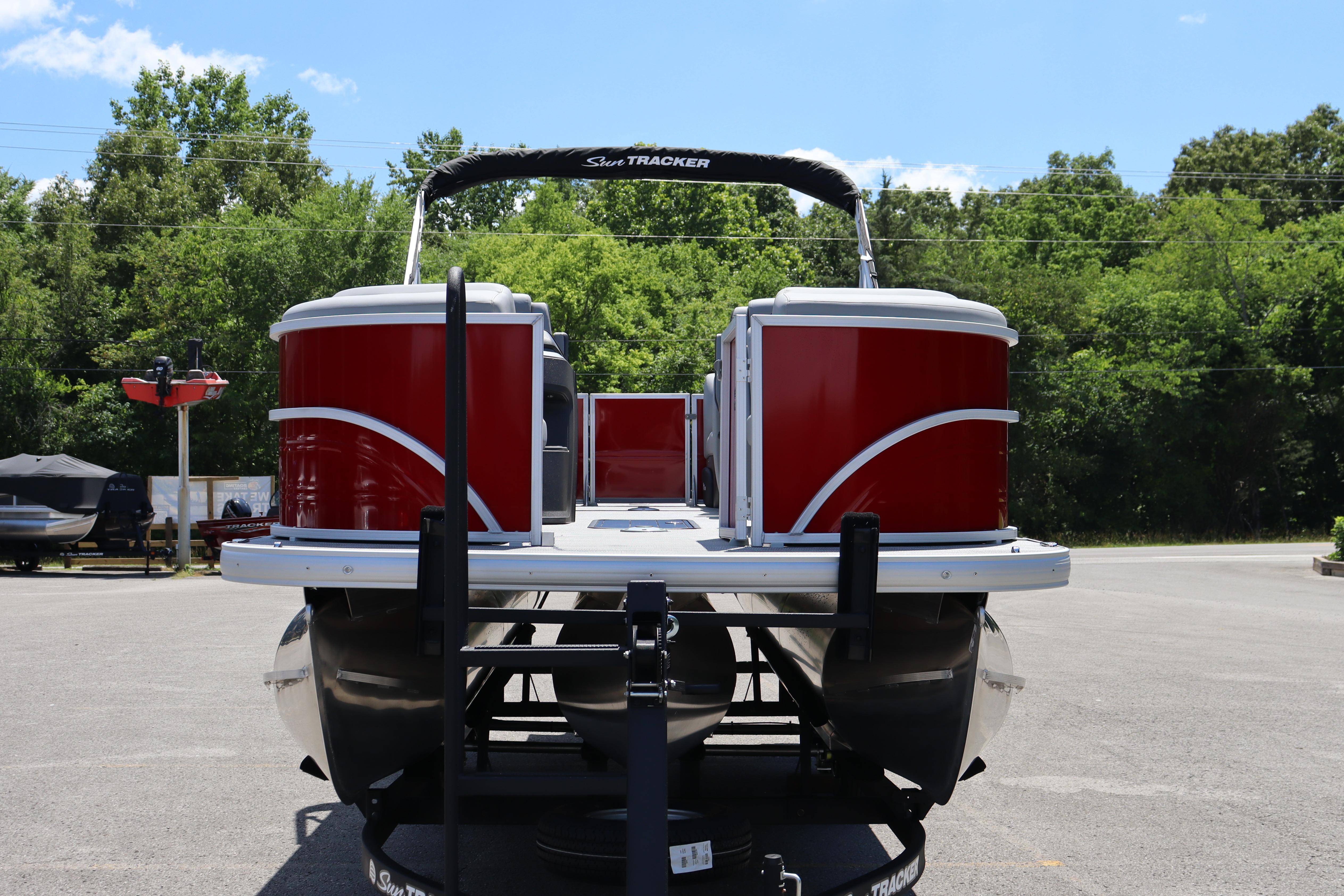 2026 Sun Tracker Party Barge 22 XP3 pontoon boat on trailer, surrounded by trees.