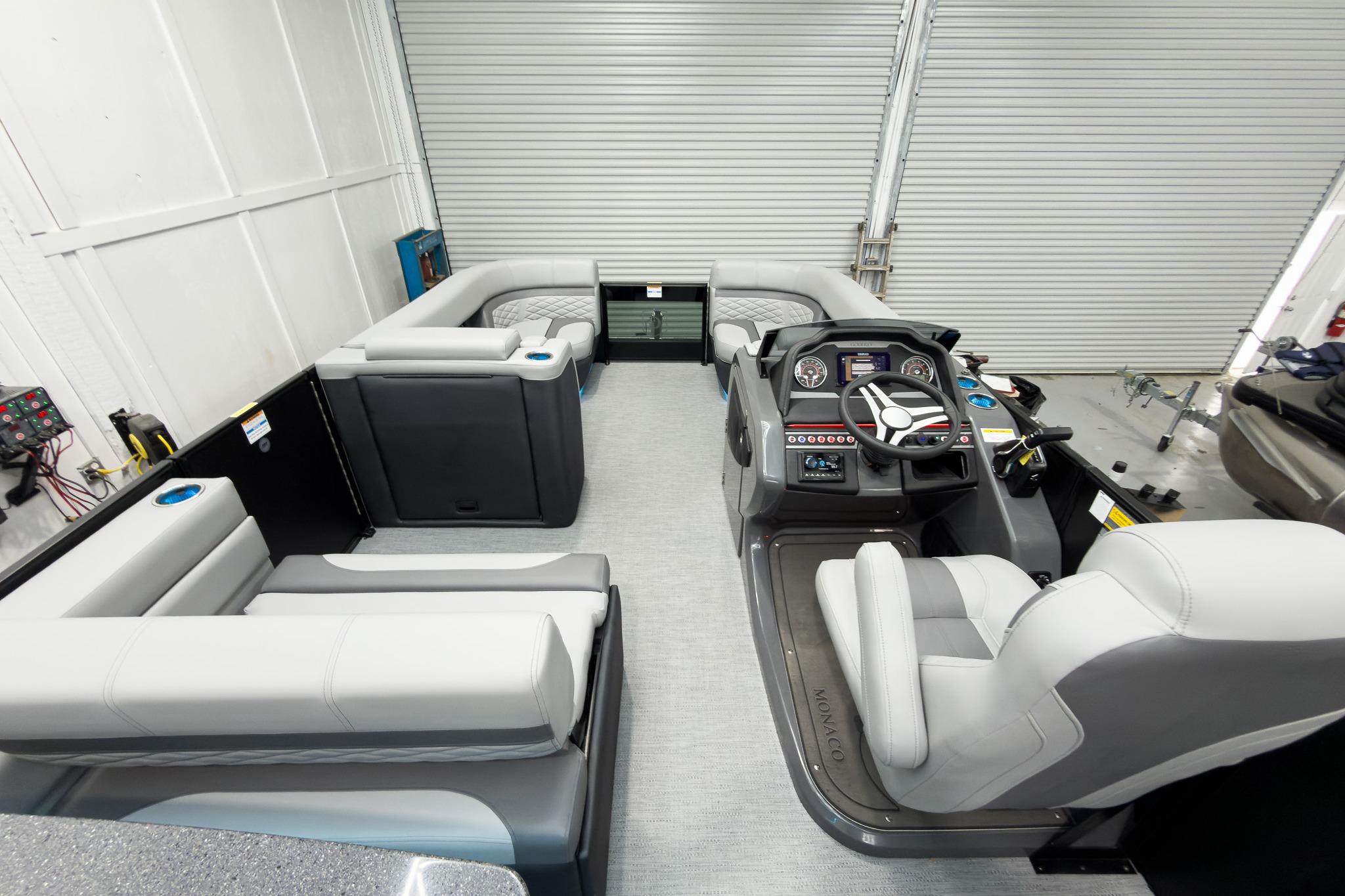 2026 Godfrey Monaco 25' Tritoon interior with mid-table flip lounge and modern helm.