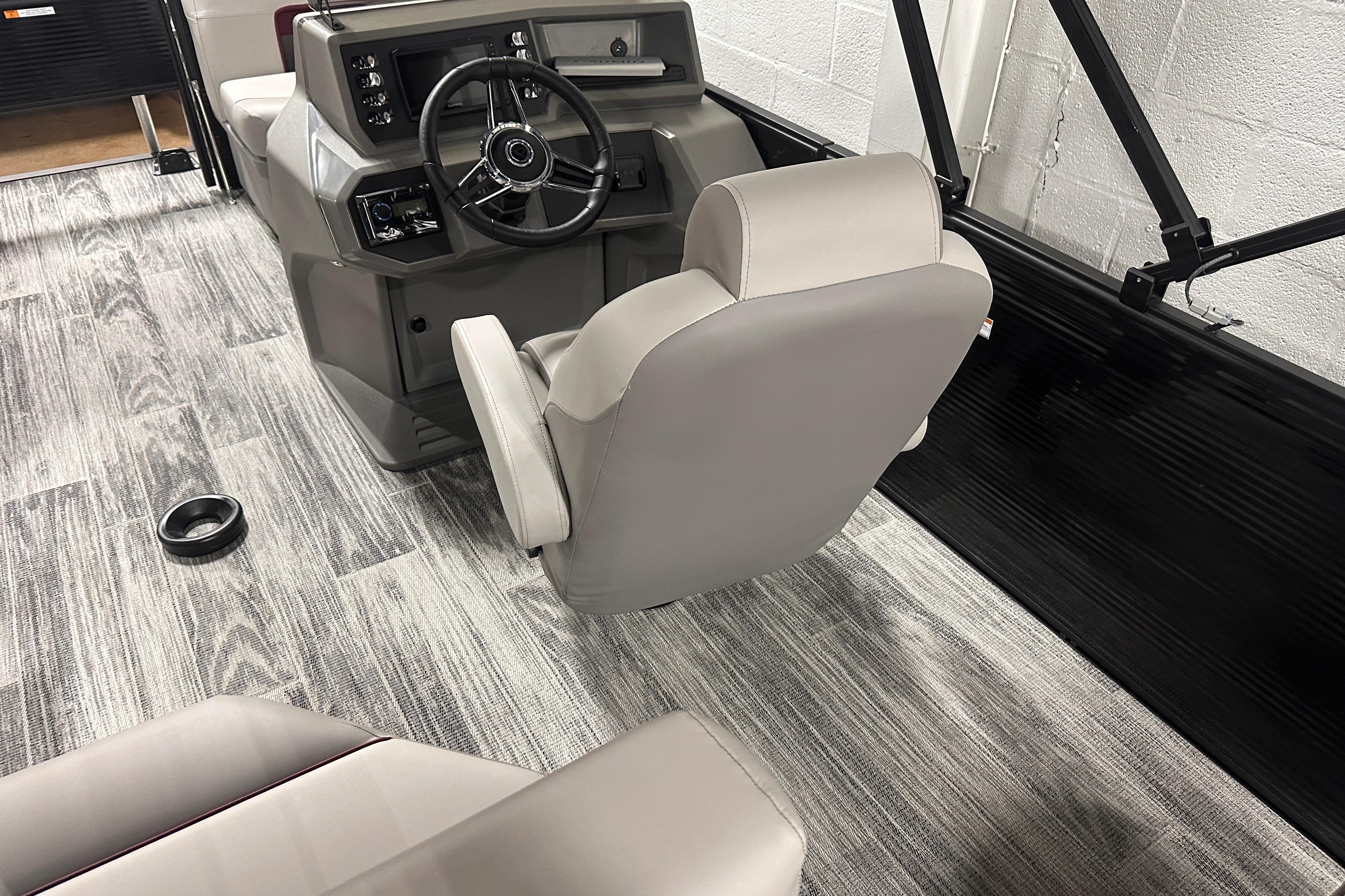 Interior of 2025 Qwest 18 XRE Cruise boat with modern steering console and seating.