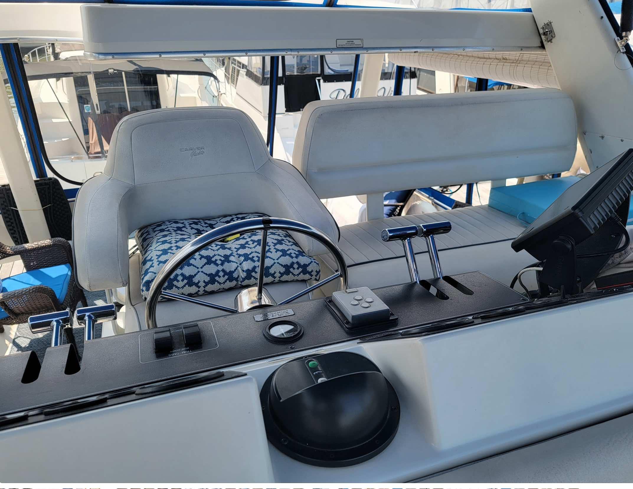 1992 Carver 33 Aft Cabin helm with steering wheel, controls, and cushioned seating.