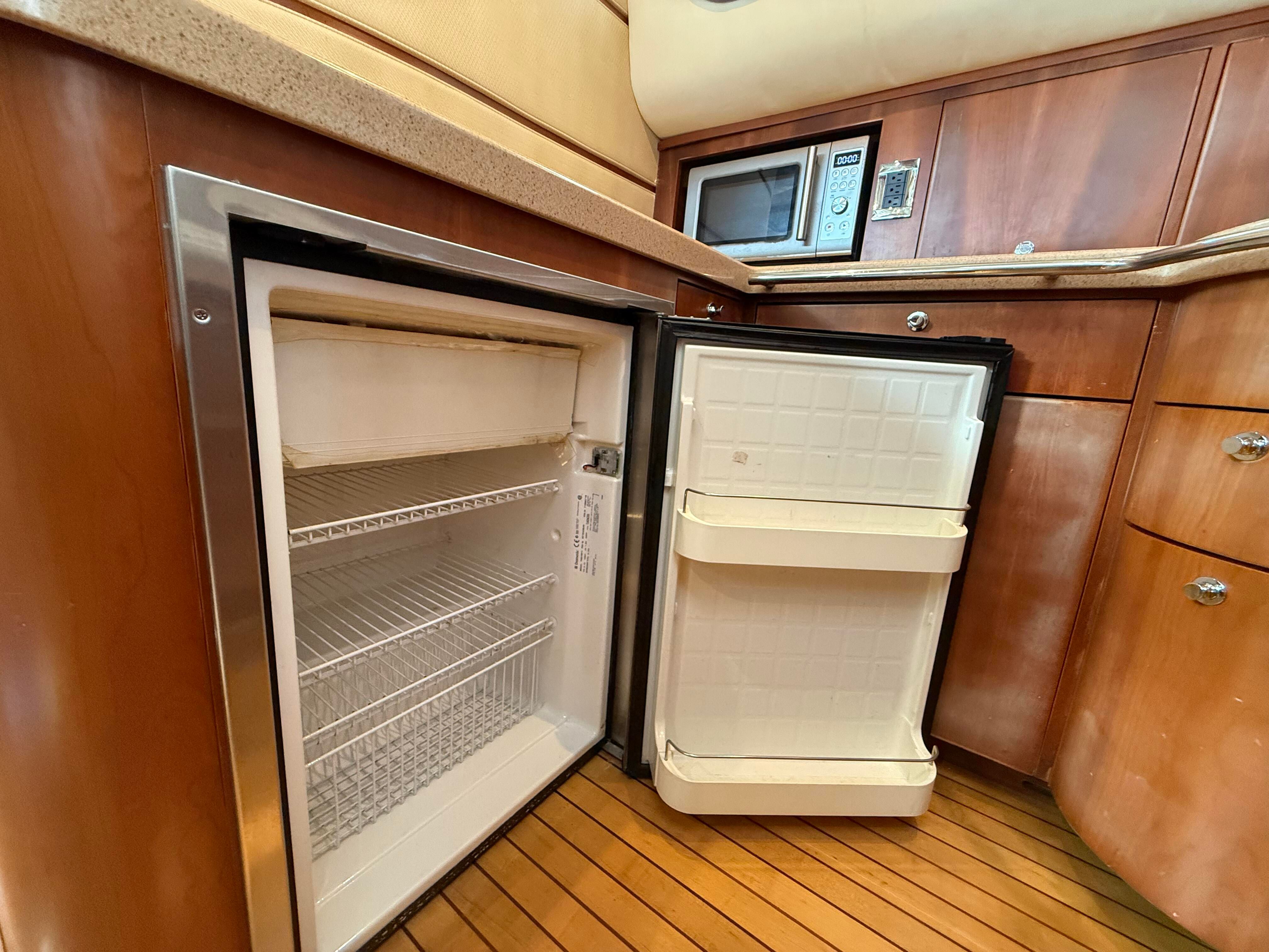 Galley with open fridge and microwave on a 2007 Chris-Craft Roamer 40.