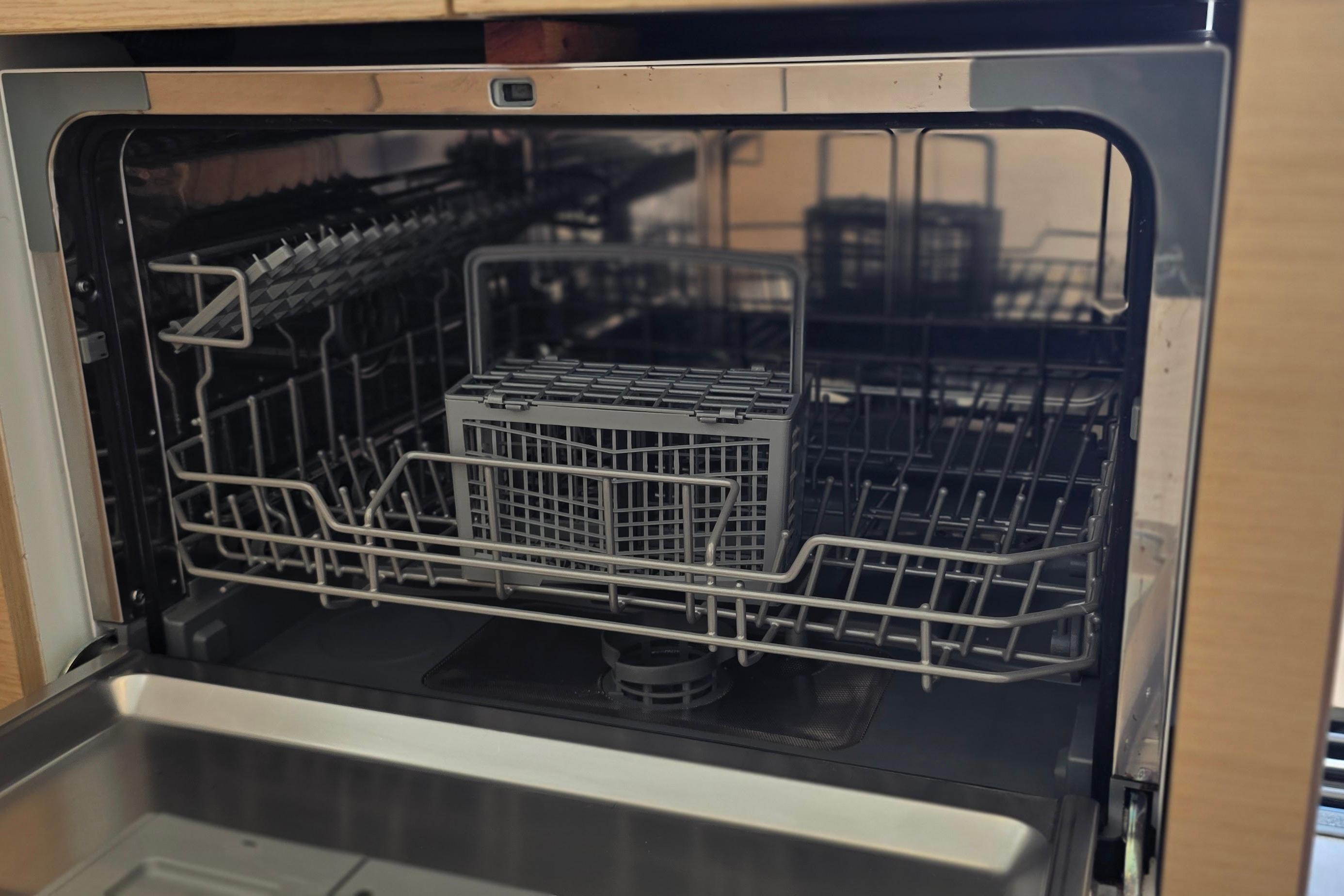 Open dishwasher inside a 2018 Fountaine Pajot Motor Yacht 44, showcasing racks and cutlery basket.
