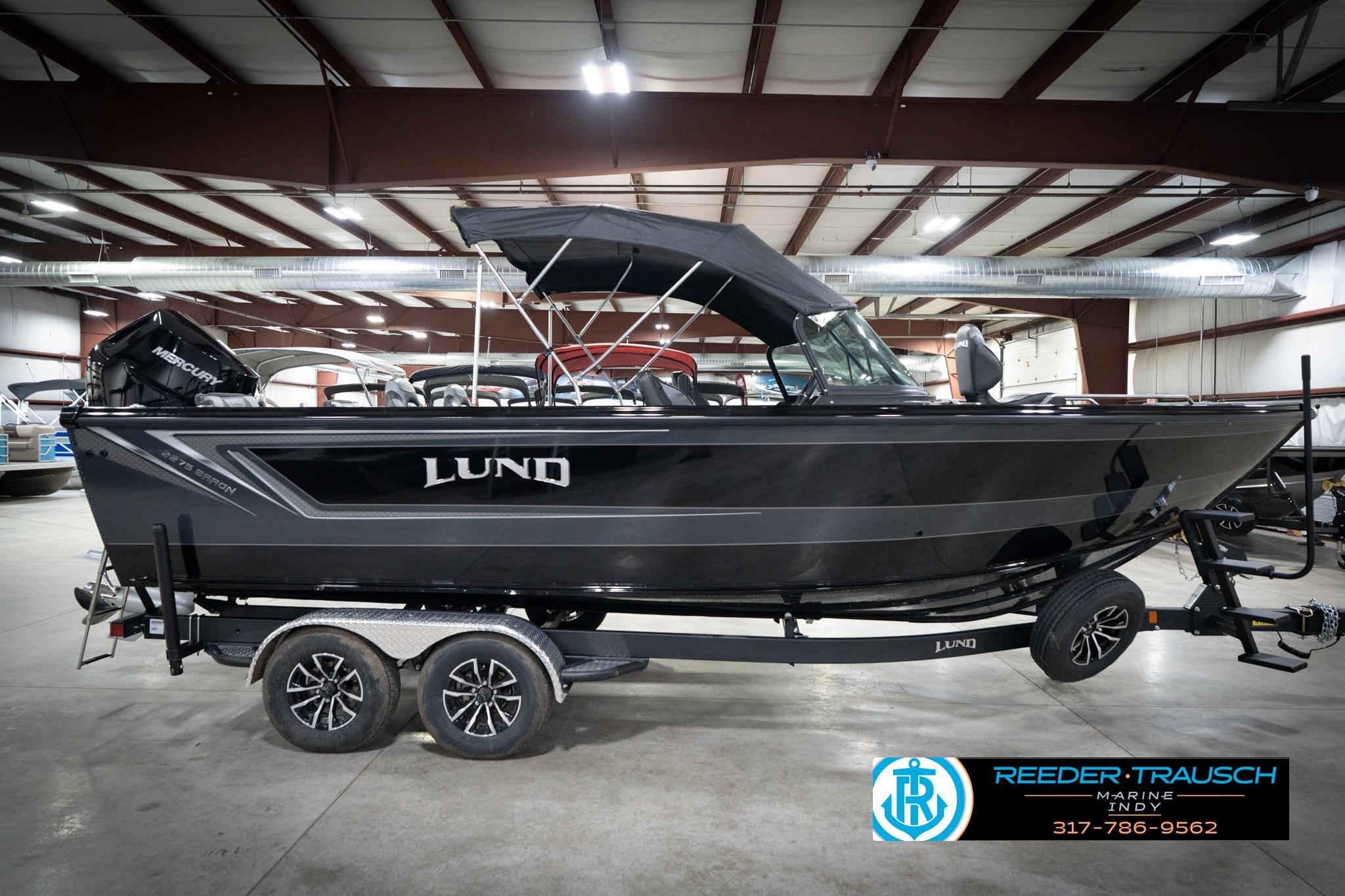 2026 Lund 2275 Baron boat in showroom, side view with trailer.