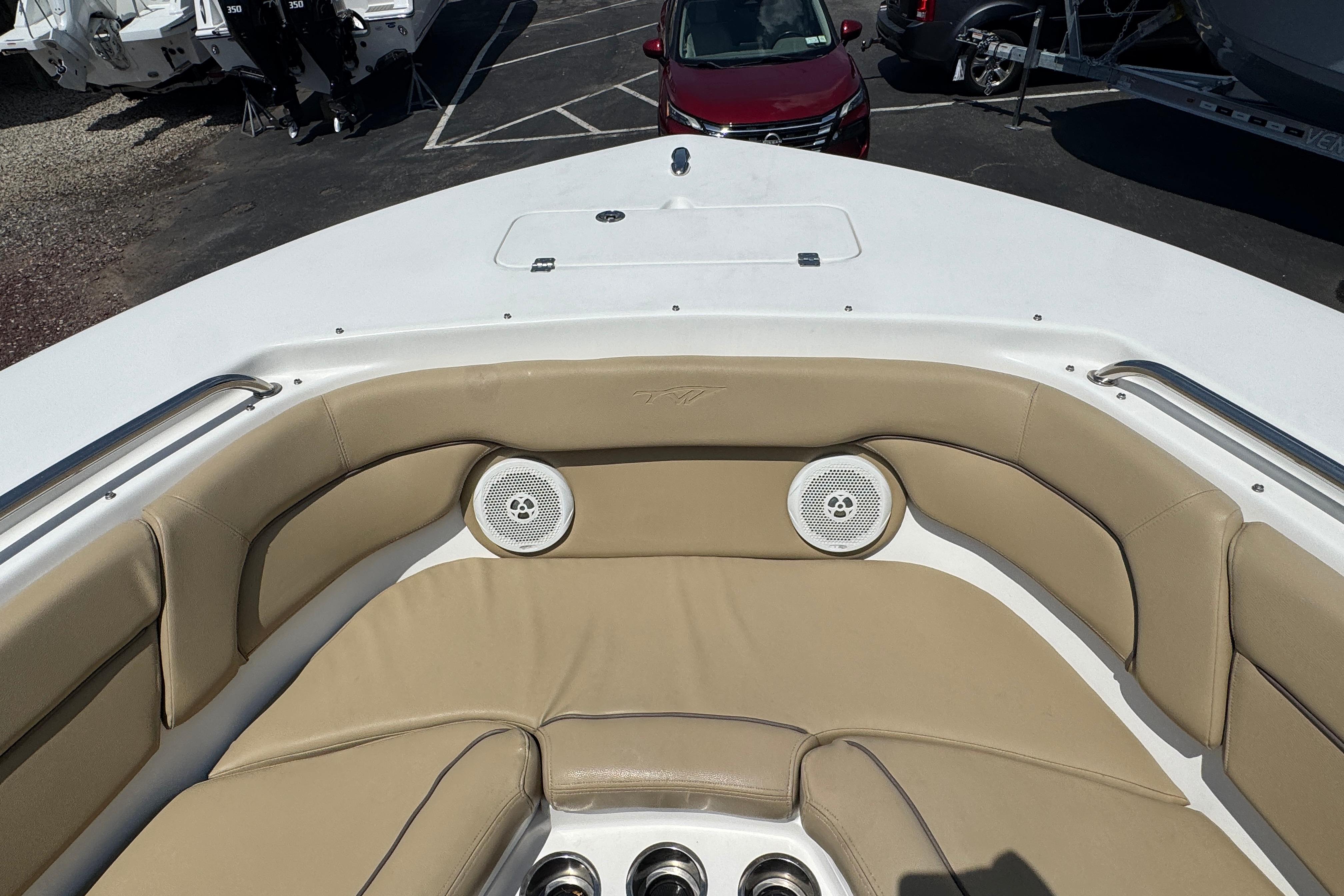Bow seating area of a 2016 Tidewater 230 LXF boat with beige cushions.