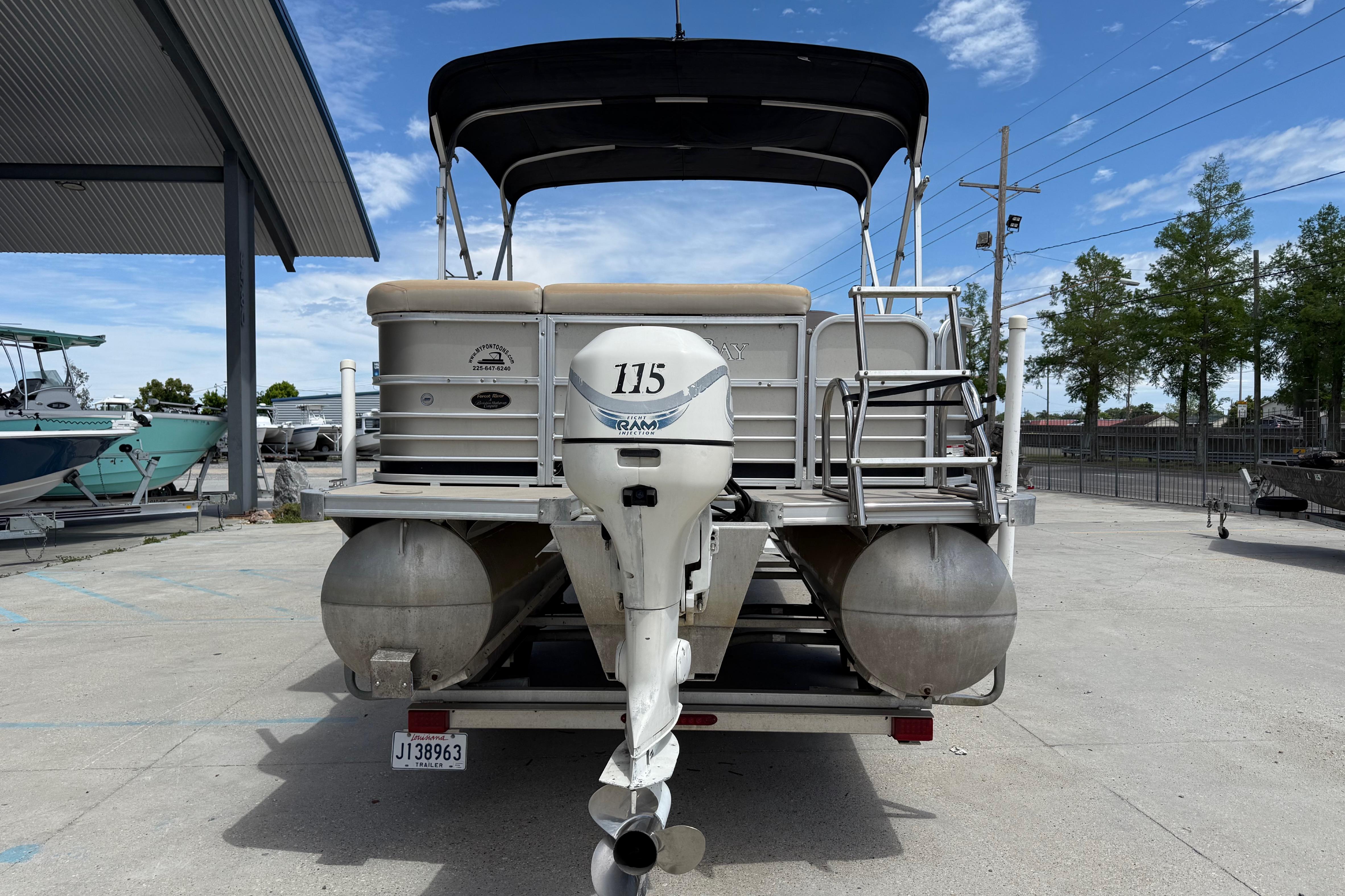 2012 South Bay 522 CR pontoon boat with outboard motor, parked outdoors under blue sky.