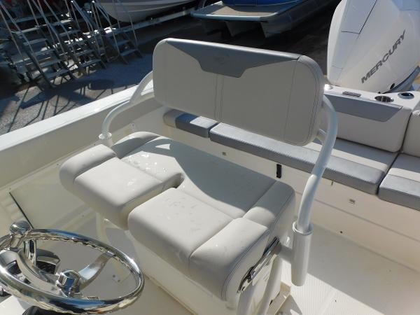2025 Sailfish 232 CC boat interior with white cushioned seating and steering wheel.