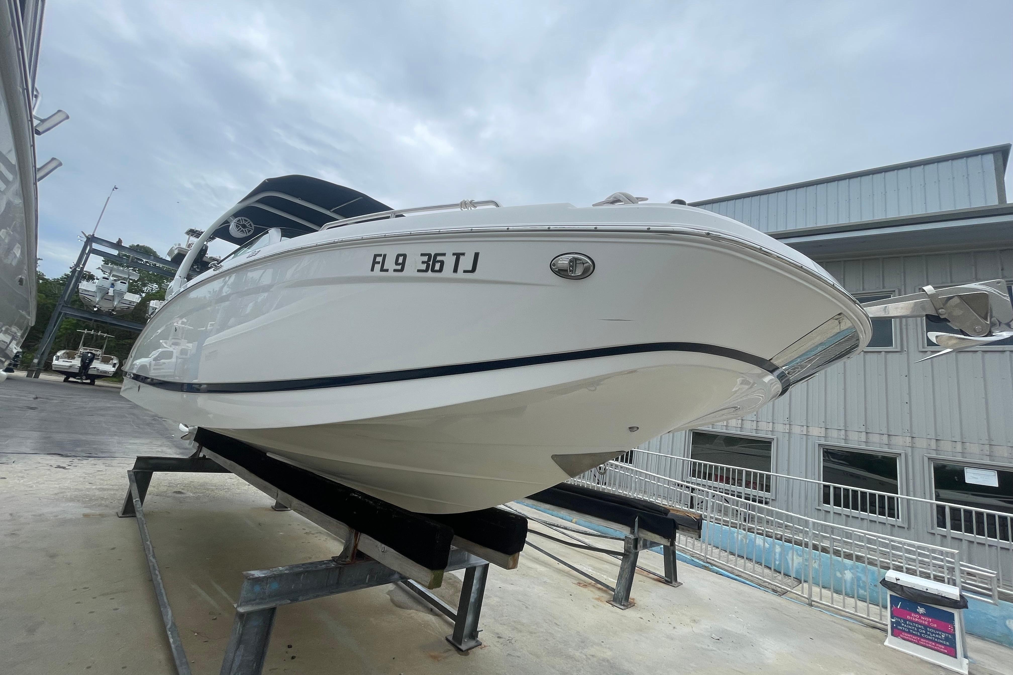 2022 Four Winns HD8 OB boat on display, elevated on a stand, with overcast sky.