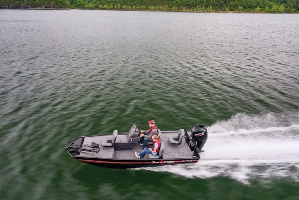 2026 Tracker Bass Tracker Classic XL boat speeding on a lake with two passengers.