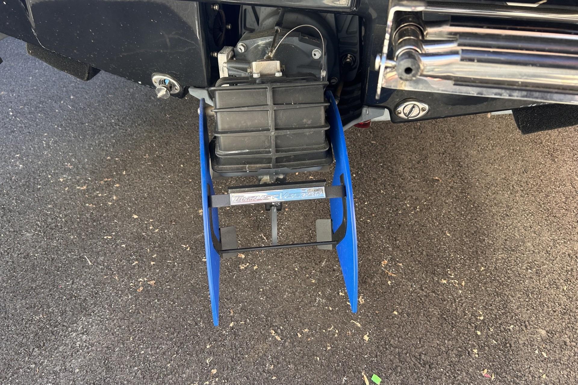2024 Yamaha Boats AR190 jet propulsion system with blue fins on asphalt surface.