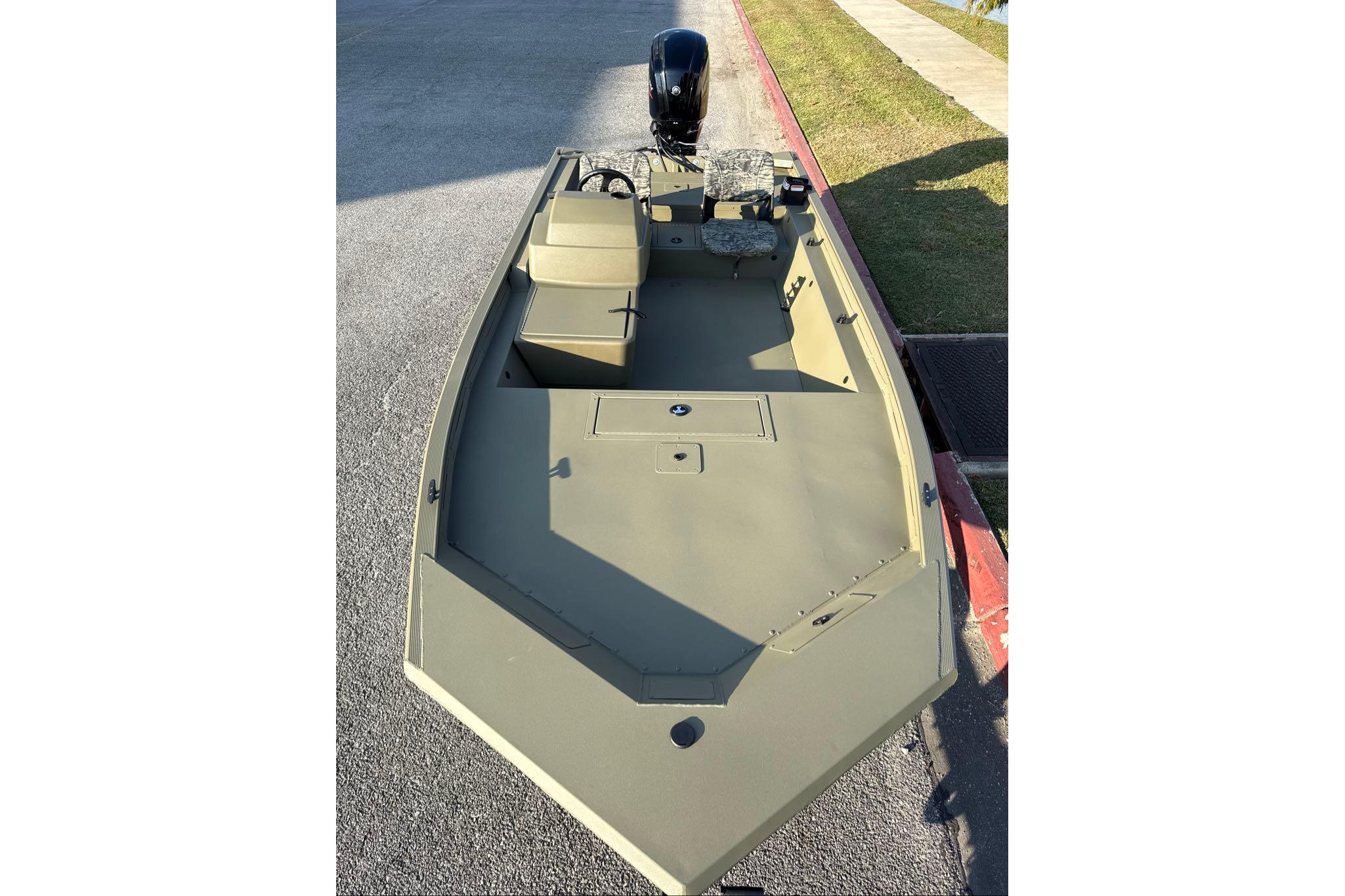 2026 Tracker Grizzly 1754 SC boat, olive green, parked on pavement.
