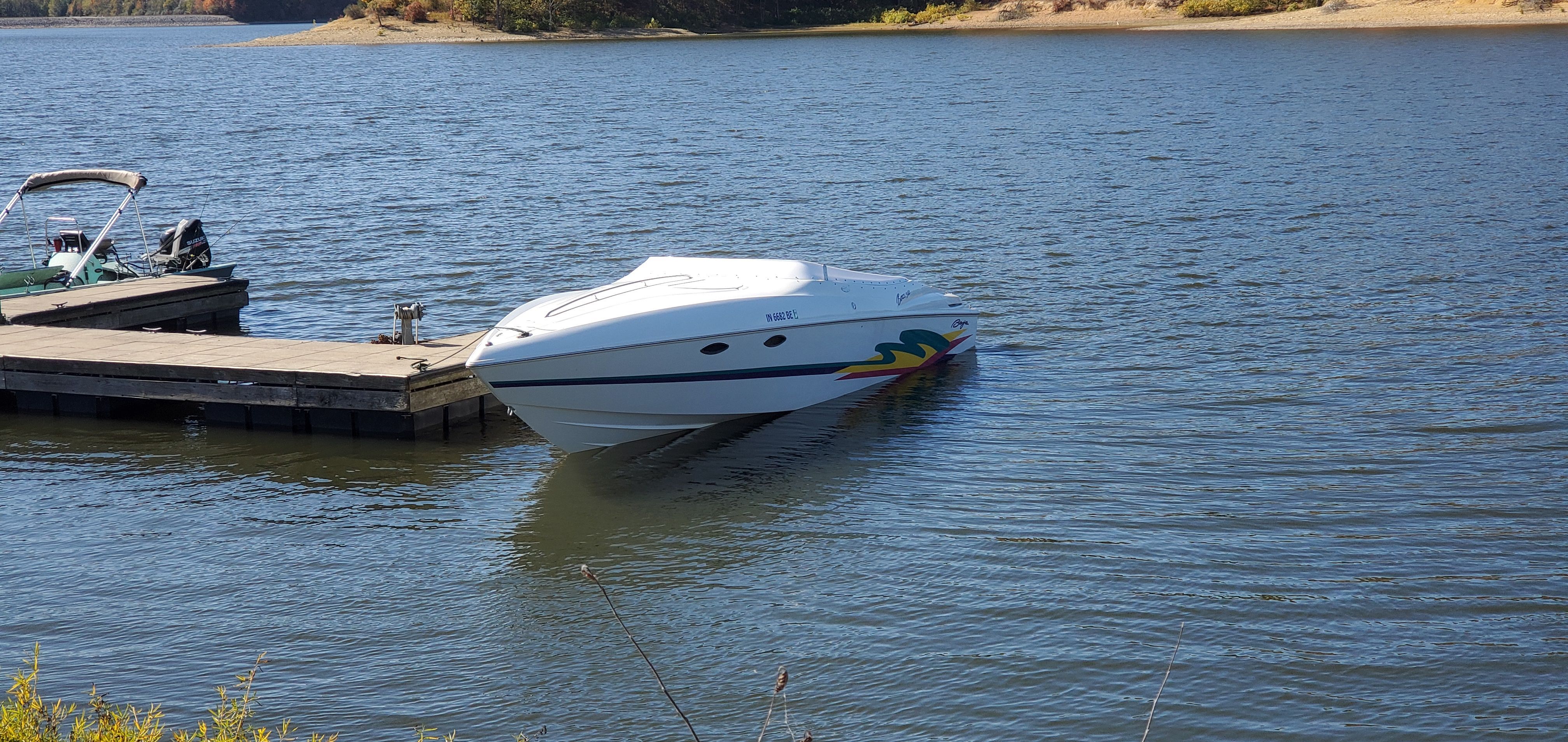 A 1996 Baja 302 Boss is docked in calm waters, featuring sleek lines and colorful graphics.