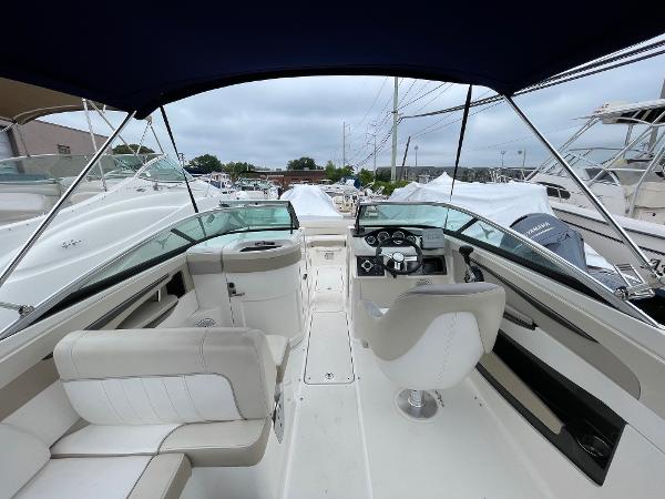 2013 Sea Ray 240 Sundeck interior with helm and seating, docked among other boats.