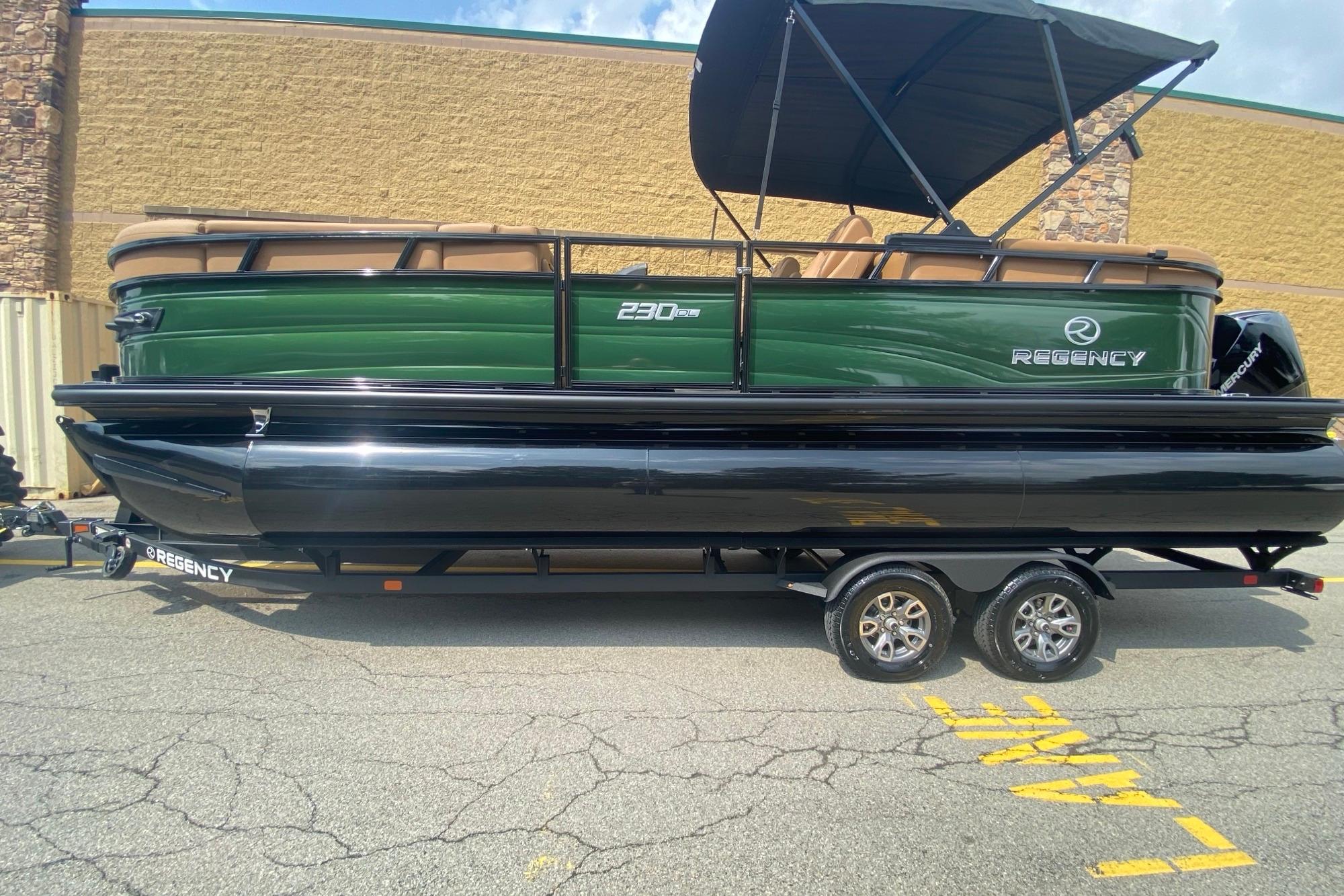 2026 Regency 230 DL pontoon boat with green and black design on a trailer.