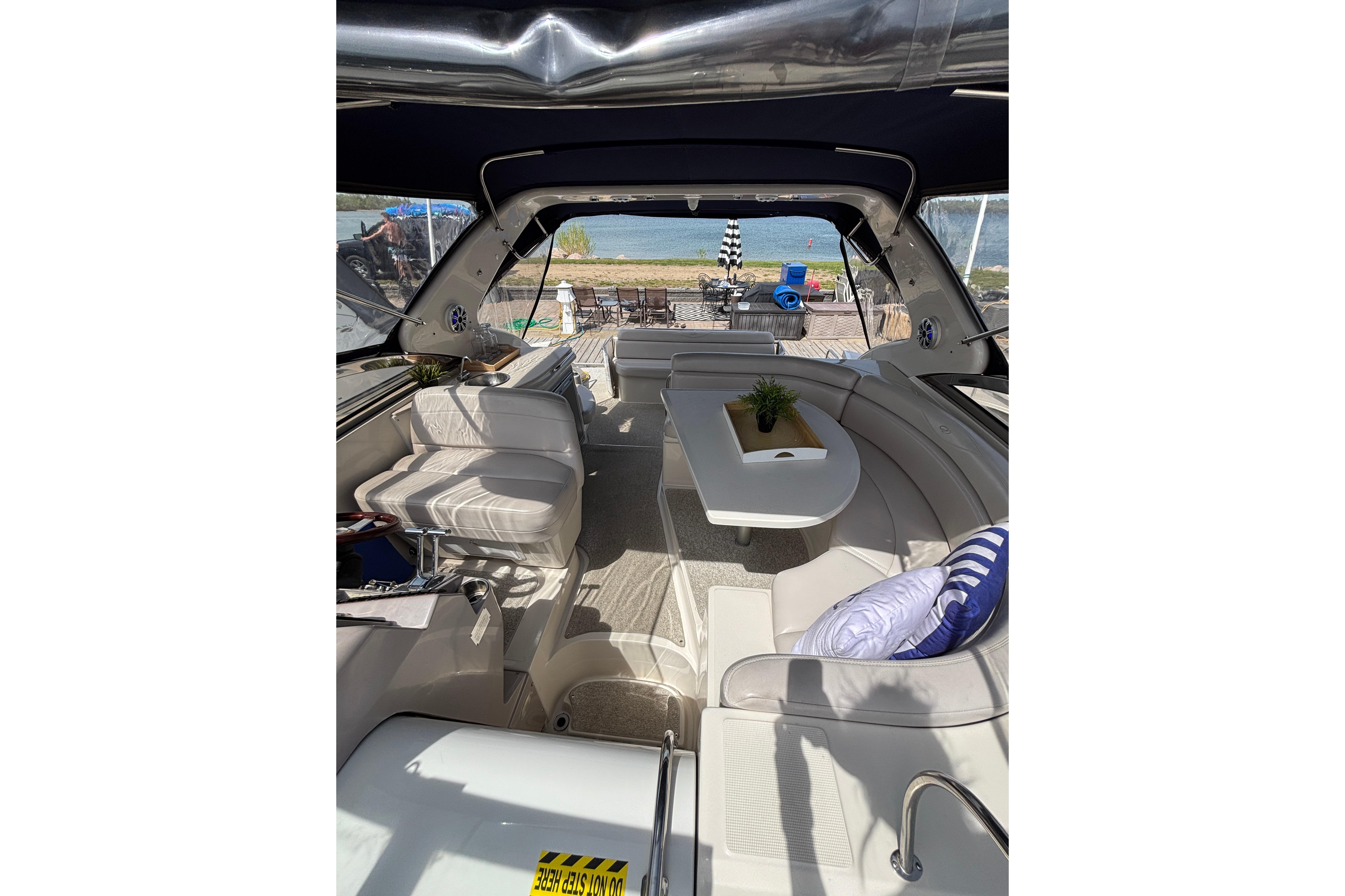 Interior of 2000 Regal Commodore 4160 yacht with plush seating and table, overlooking water.