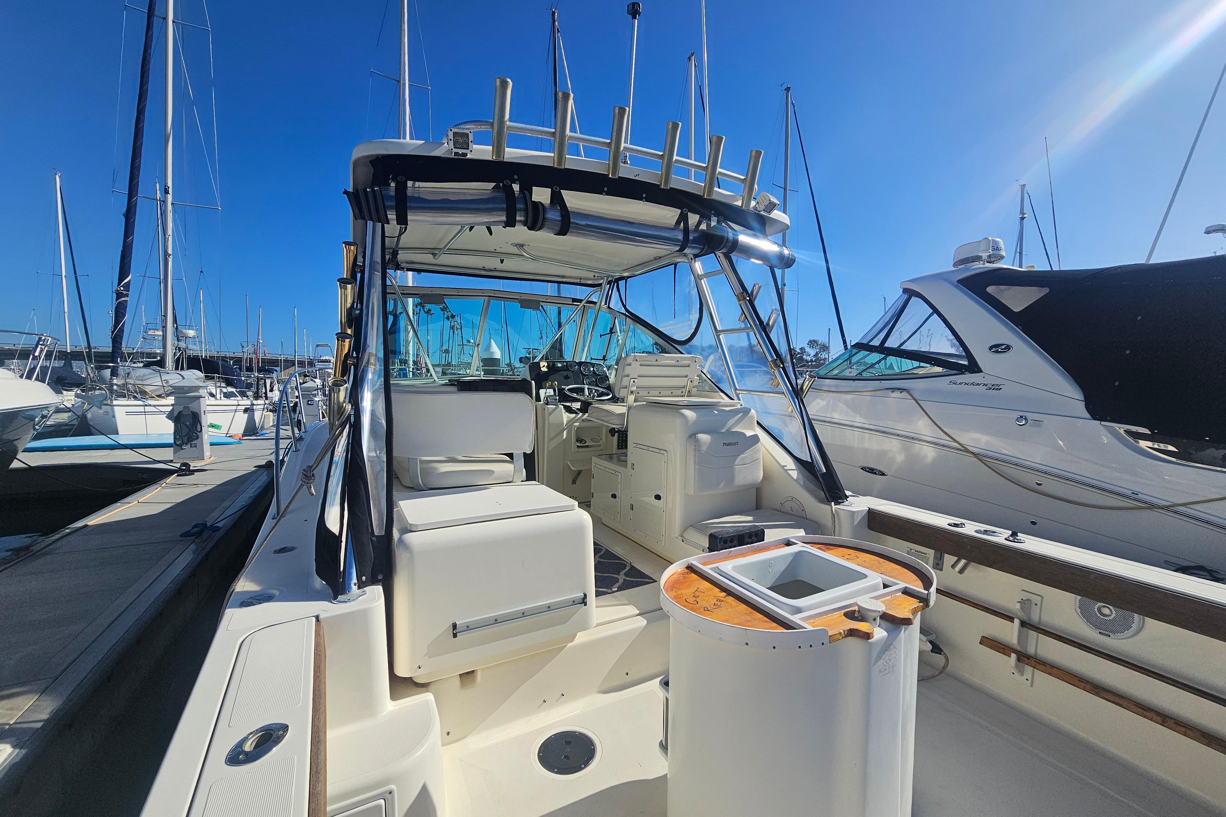 2001 Pursuit 3000 Express boat docked at marina under clear blue sky.