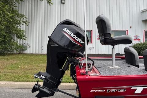 2026 Tracker Pro 170 boat with Mercury outboard motor, parked near a building.