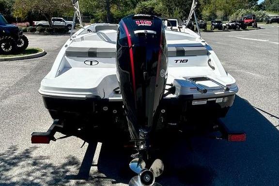 2025 Tahoe T18 boat with Mercury outboard motor in a parking lot.