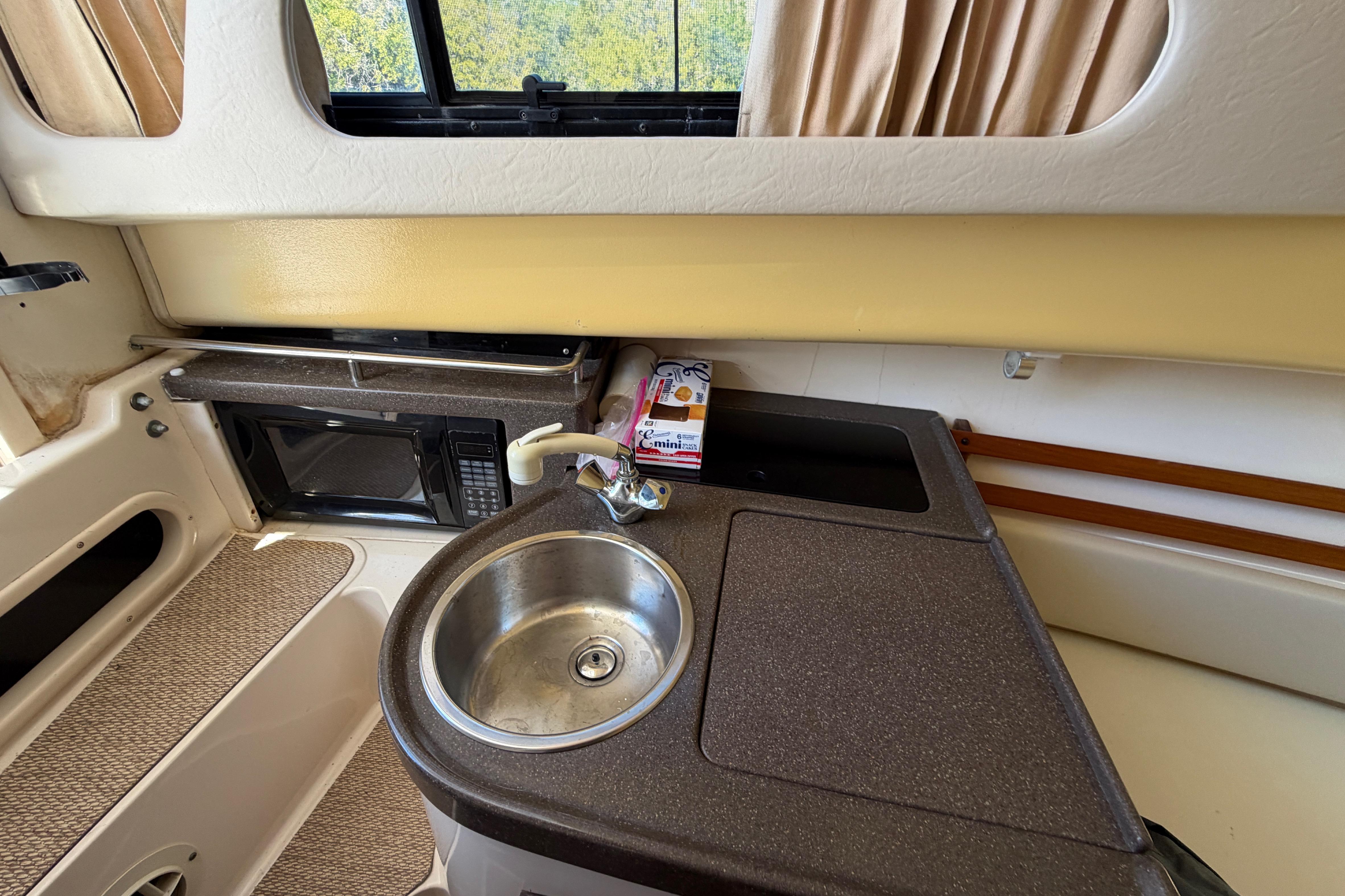 2006 Grady-White Sailfish 282 boat interior with kitchenette, sink, and microwave.