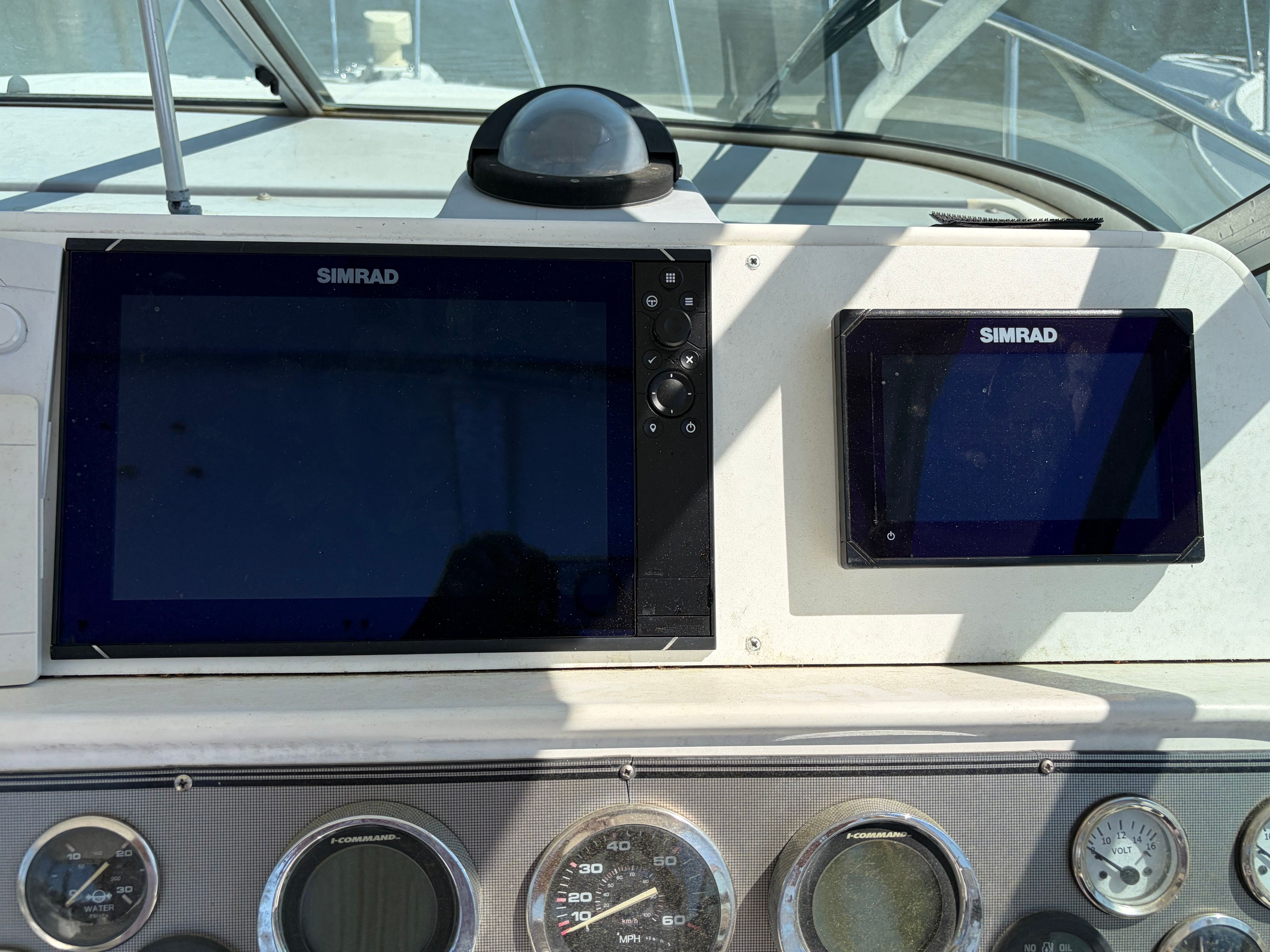 The image shows the dashboard of a 2000 Wellcraft 290 Coastal with Simrad screens.