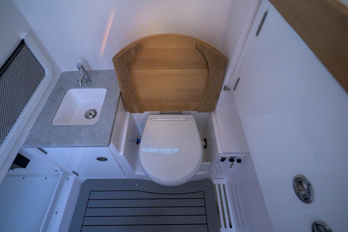 Interior of 2026 Everglades 335 Center Console boat bathroom with sink and toilet.