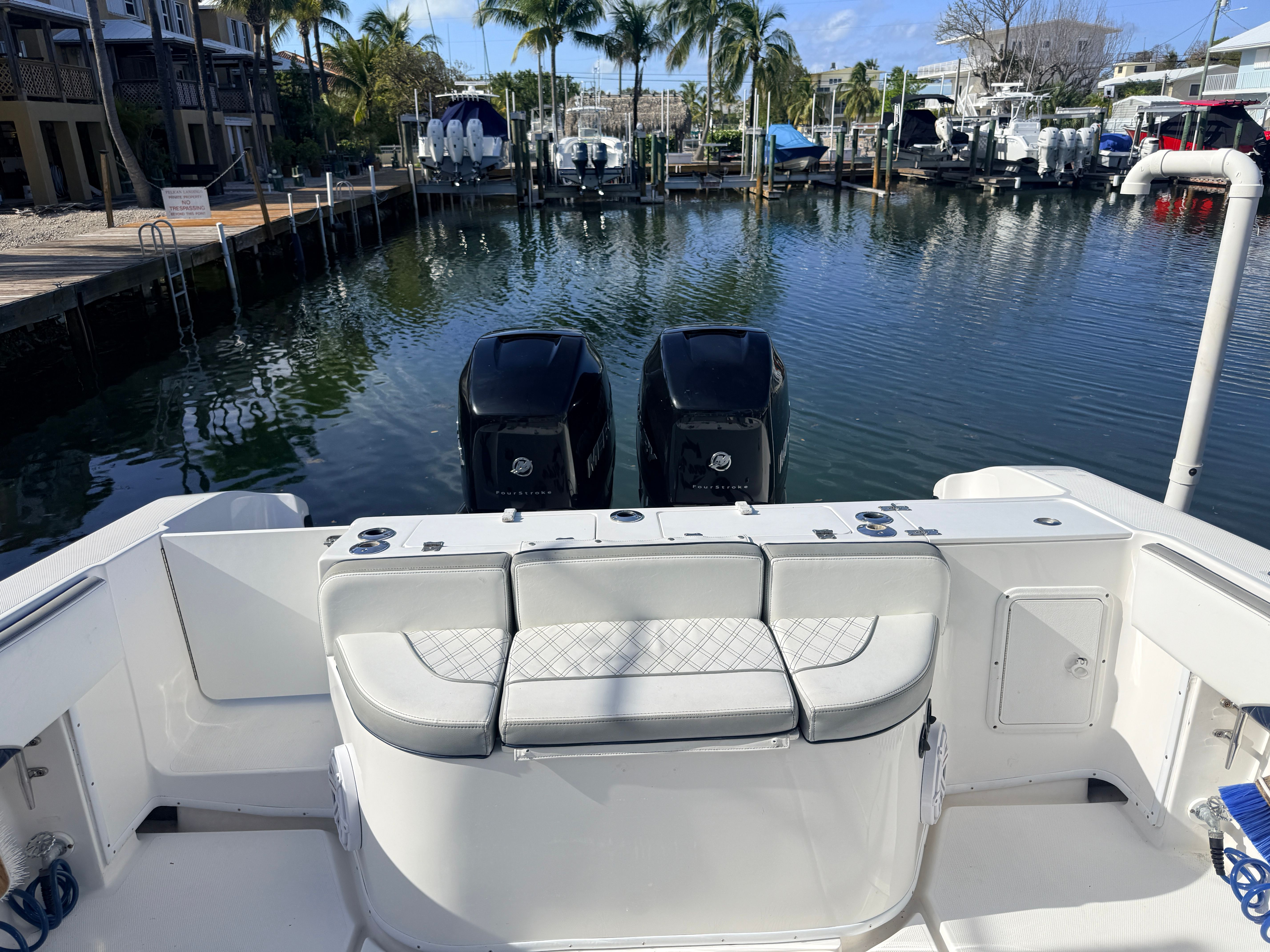 2007 Fountain 32 Center Console boat docked with palm trees in background.