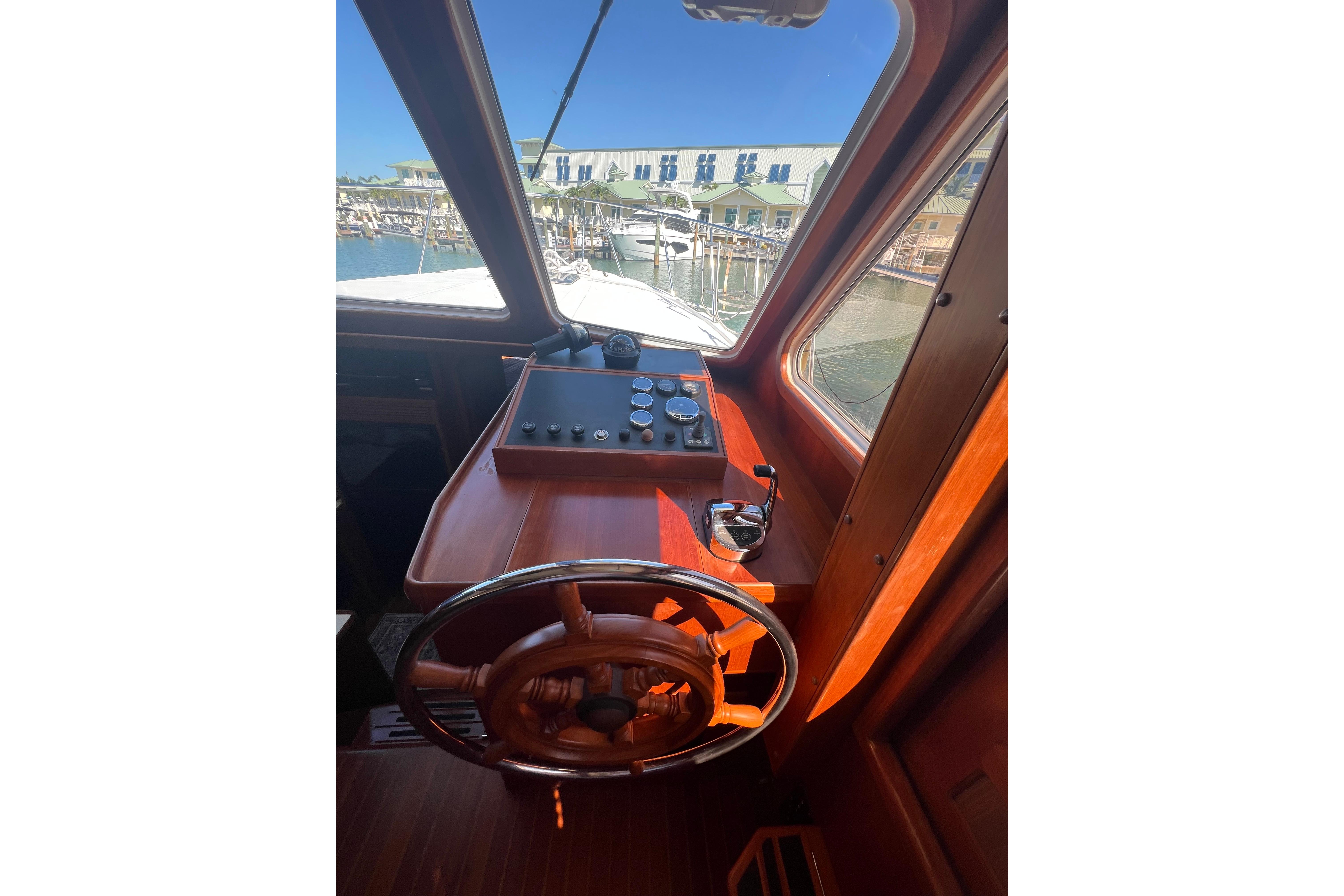 Helm of 2007 Heritage East 36 Sundeck Trawler with wooden steering wheel and control panel.