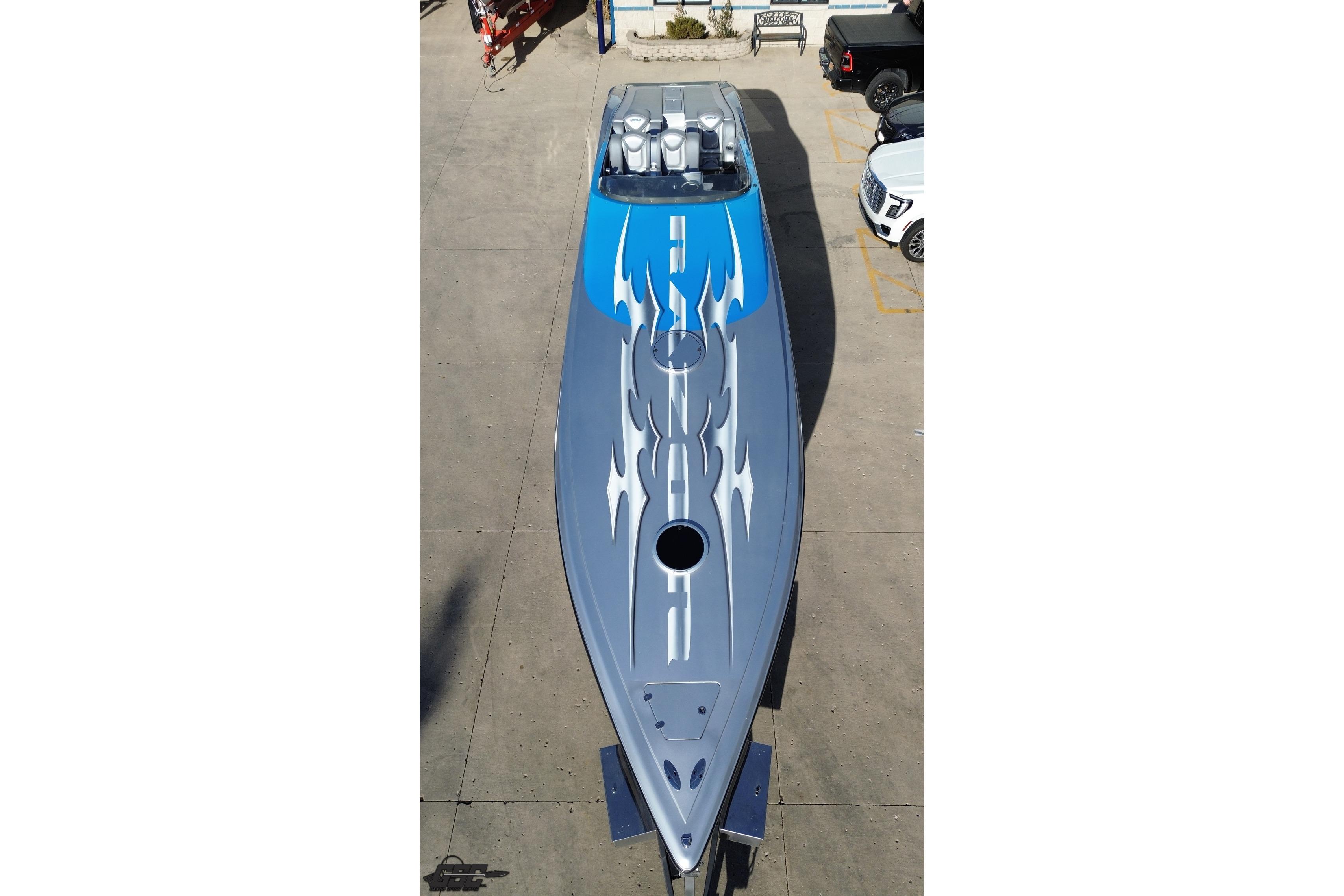 2007 Hustler 41 Razor speedboat with blue and gray flame design, aerial view.