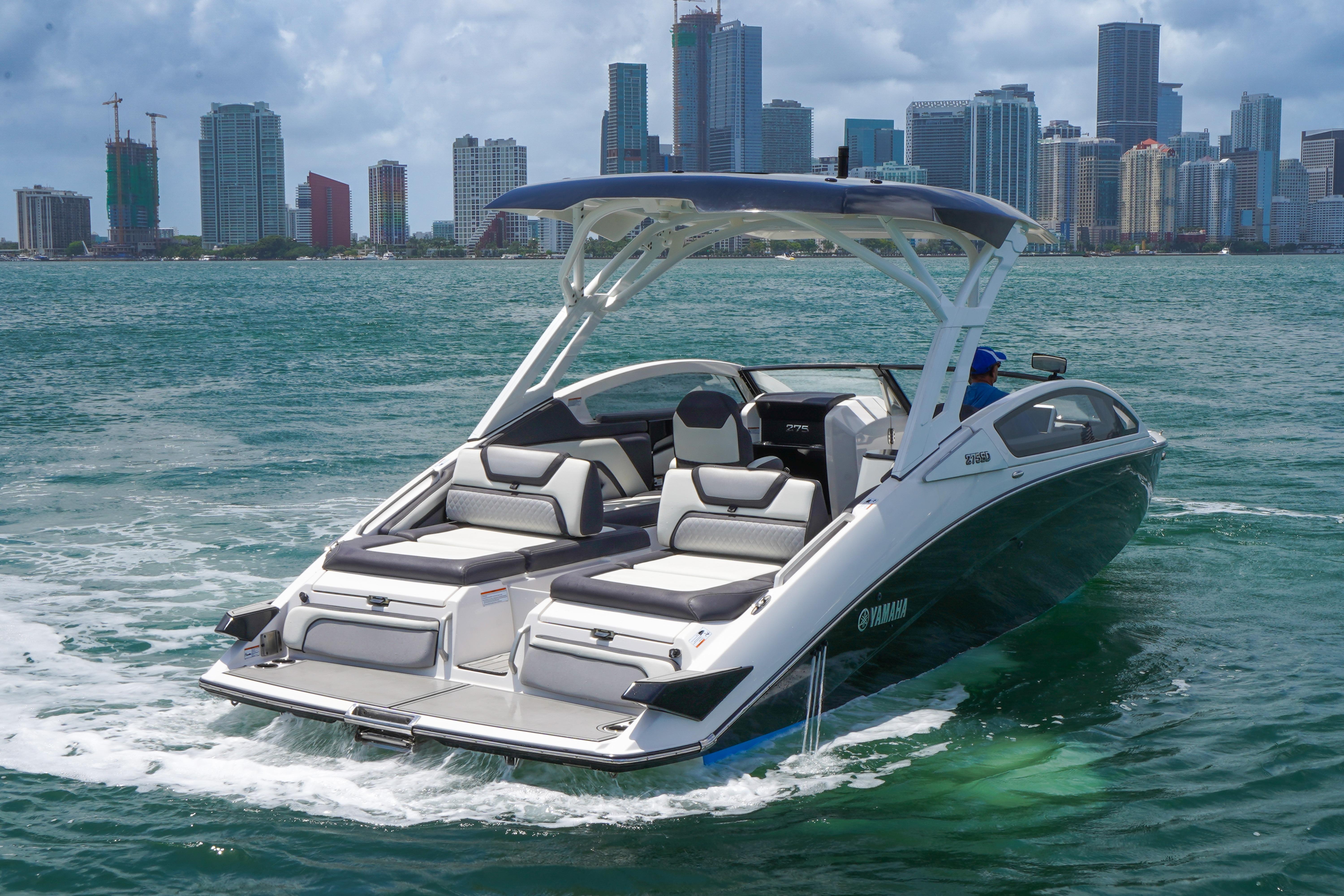 2021 Yamaha Boats 275SD cruising near city skyline on a sunny day.