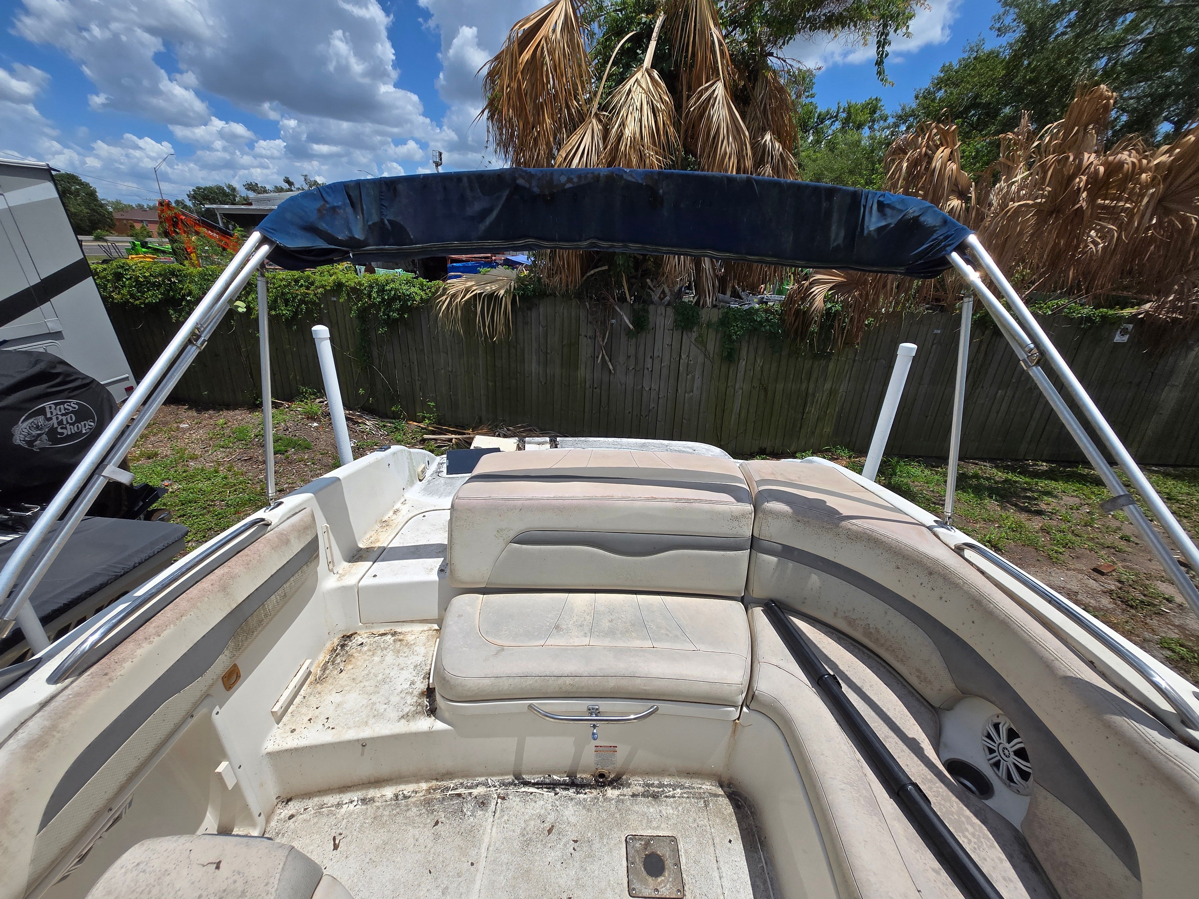 The image shows the cockpit of a 2006 Chaparral 220 SSi boat with seating and a Bimini top.