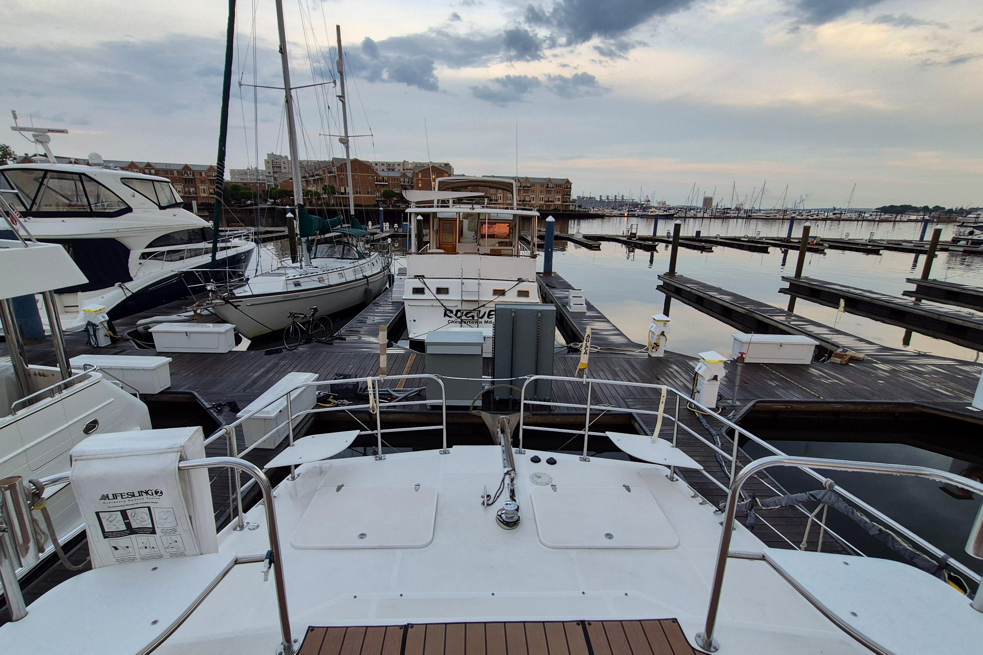 2009 Endeavour 40 Skylounge yacht docked at a marina with surrounding boats and calm waters.