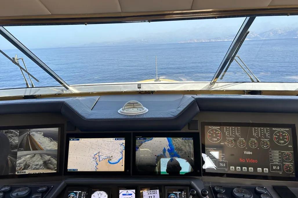 Cockpit view of 1995 Mondomarine 30 yacht with navigation screens and ocean horizon.
