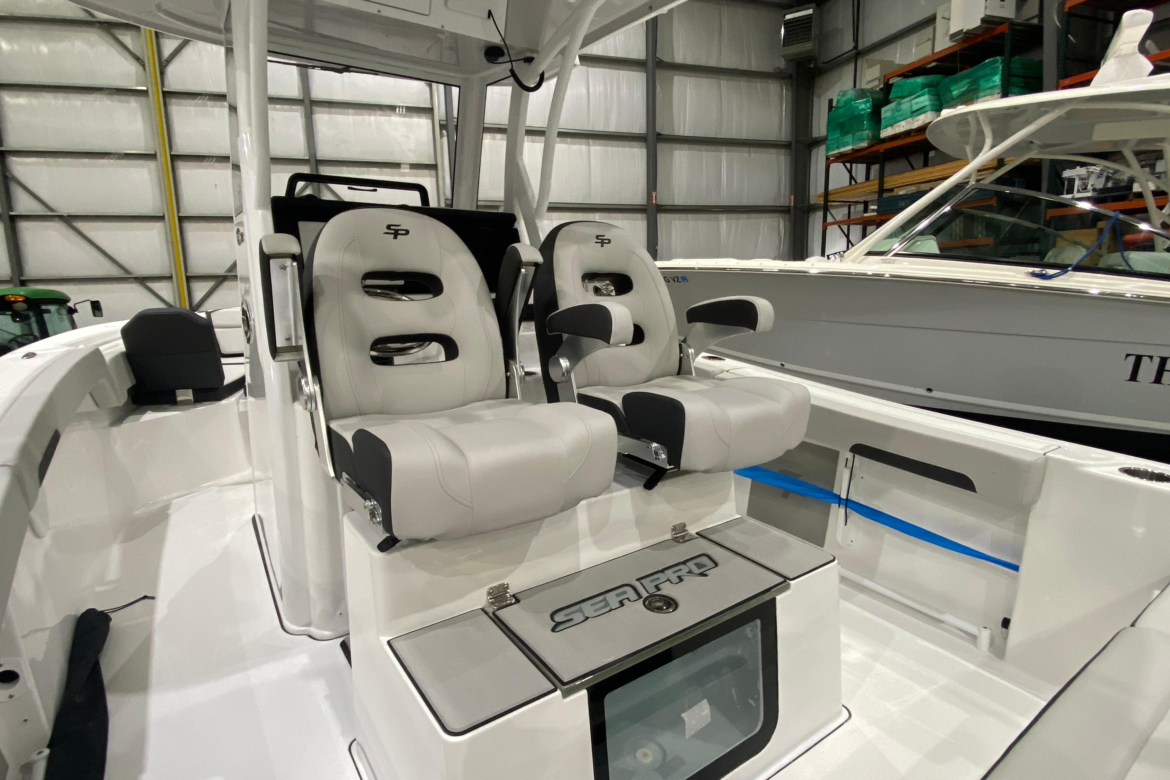 2027 Sea Pro 245FLXR Sandbar boat interior with dual cushioned seats in a showroom.