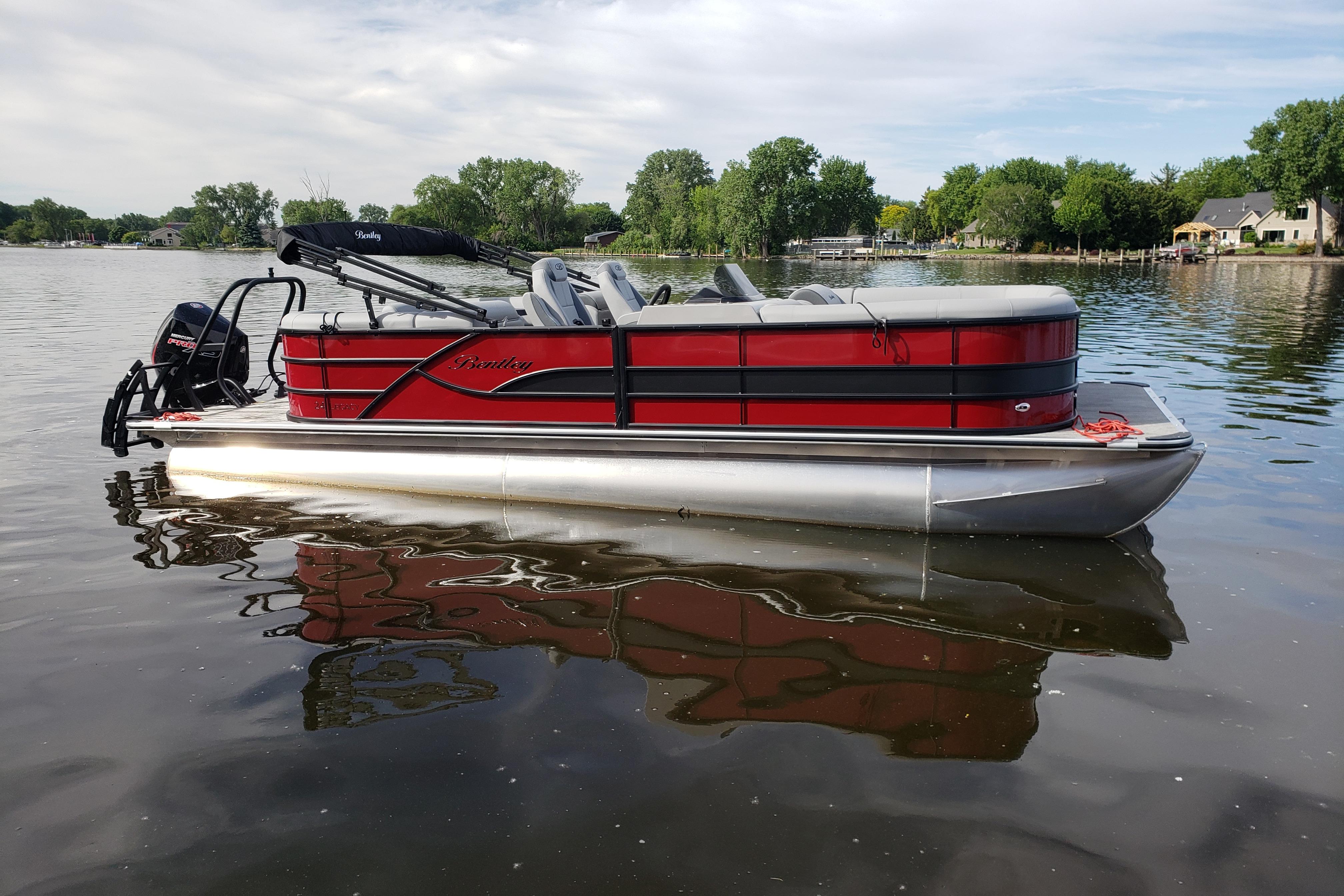 2026 Bentley Pontoons Legacy 243 Navigator Ext on a serene lake.