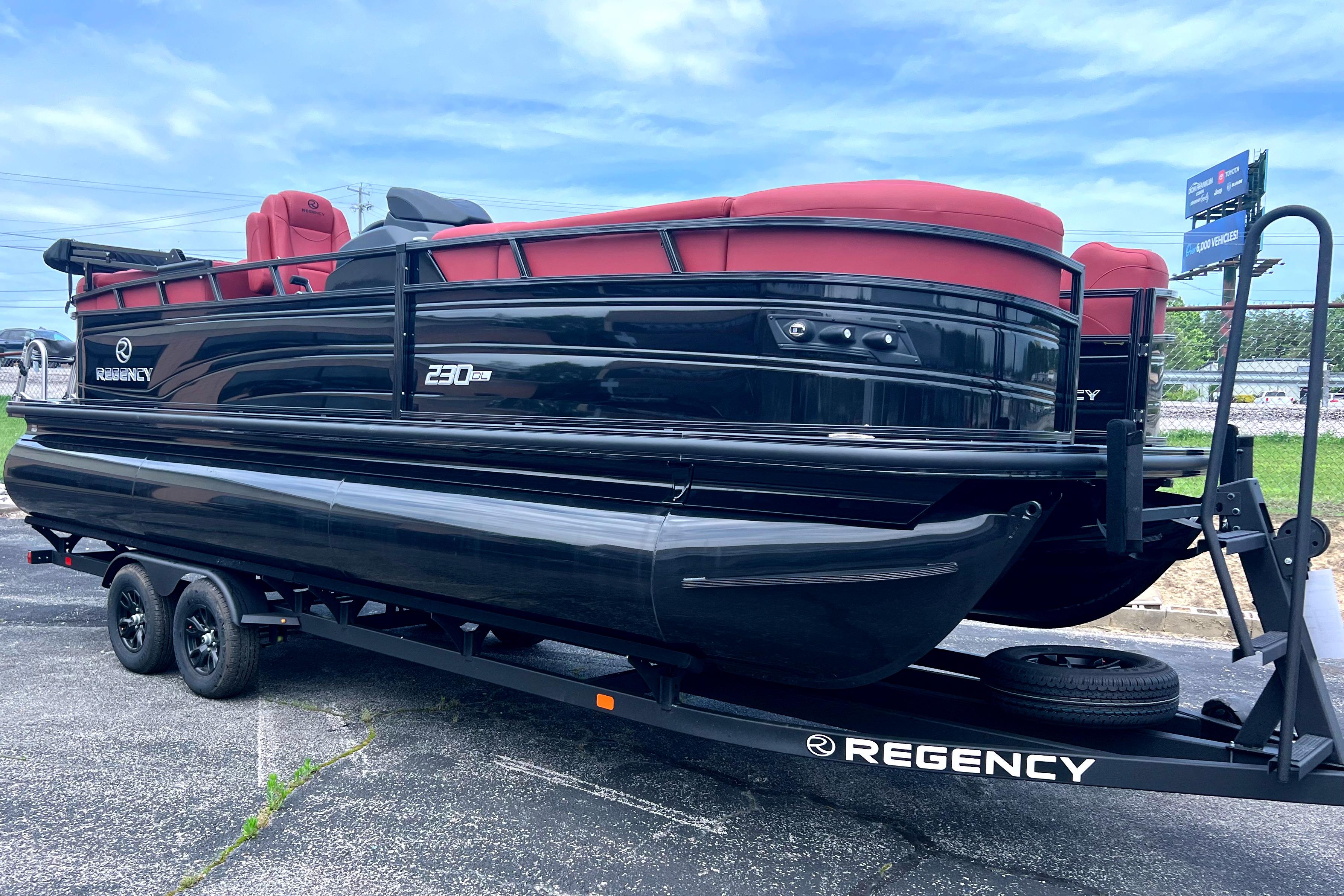 2026 Regency 230 DL pontoon boat with red seating on a trailer.
