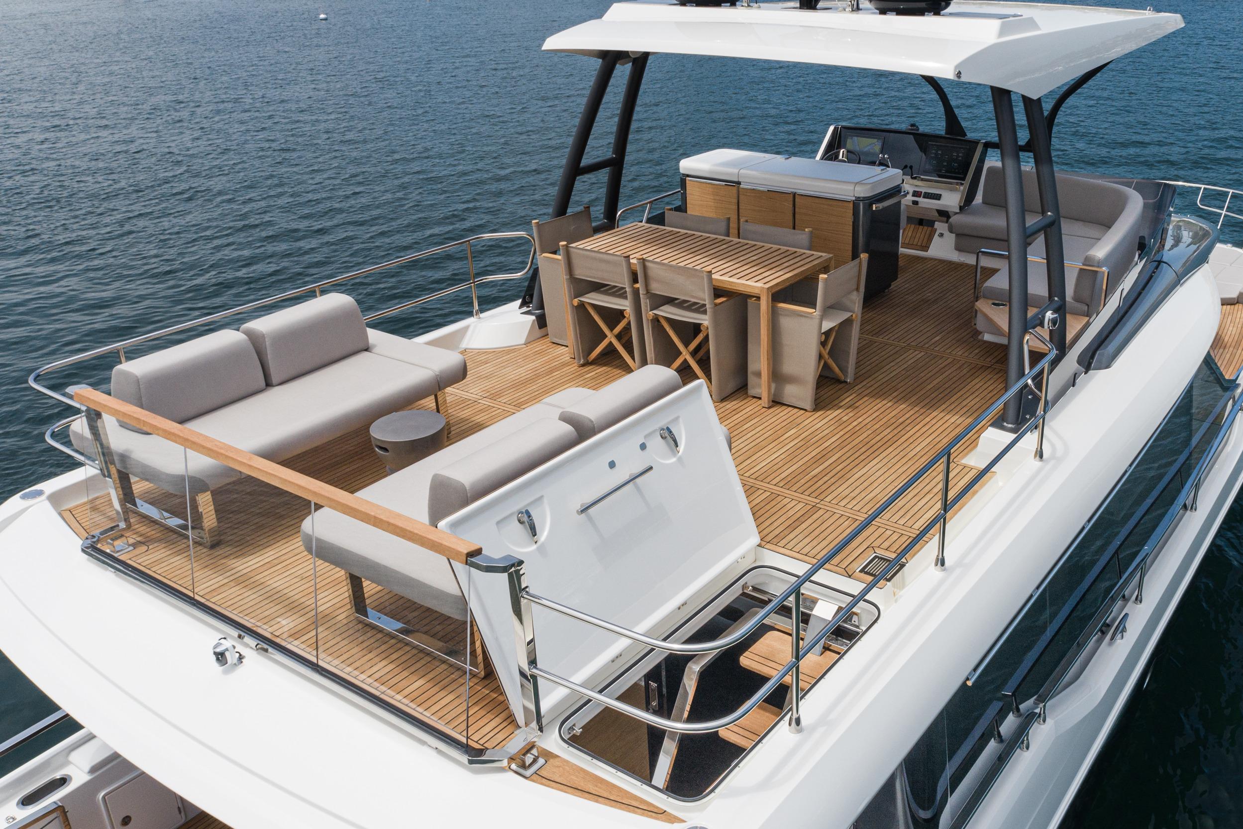 2024 Prestige X60 yacht deck with elegant seating and dining area on the water.