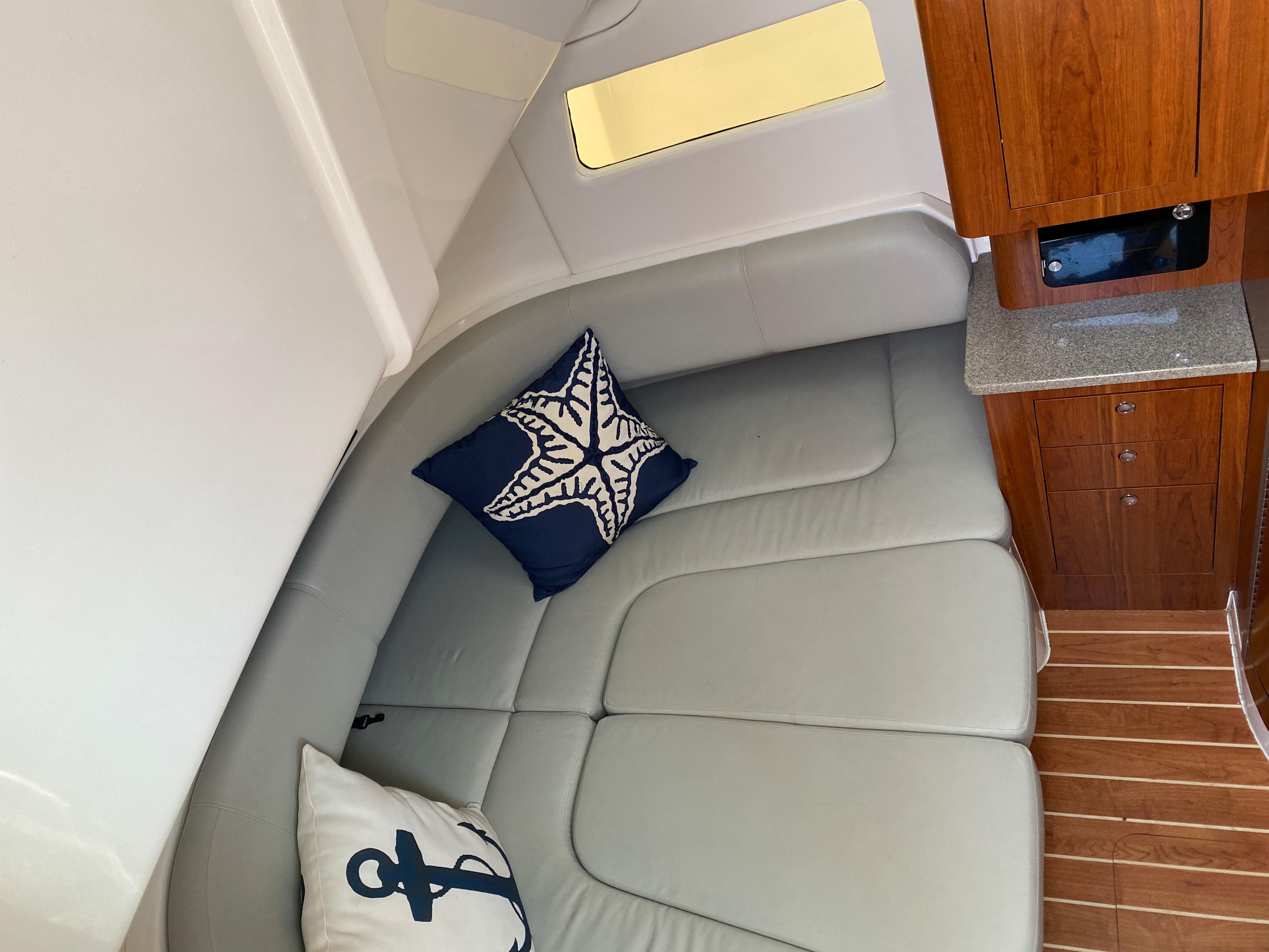 2016 Regulator 41 interior with cushioned seating, nautical-themed pillows, and wooden cabinetry.