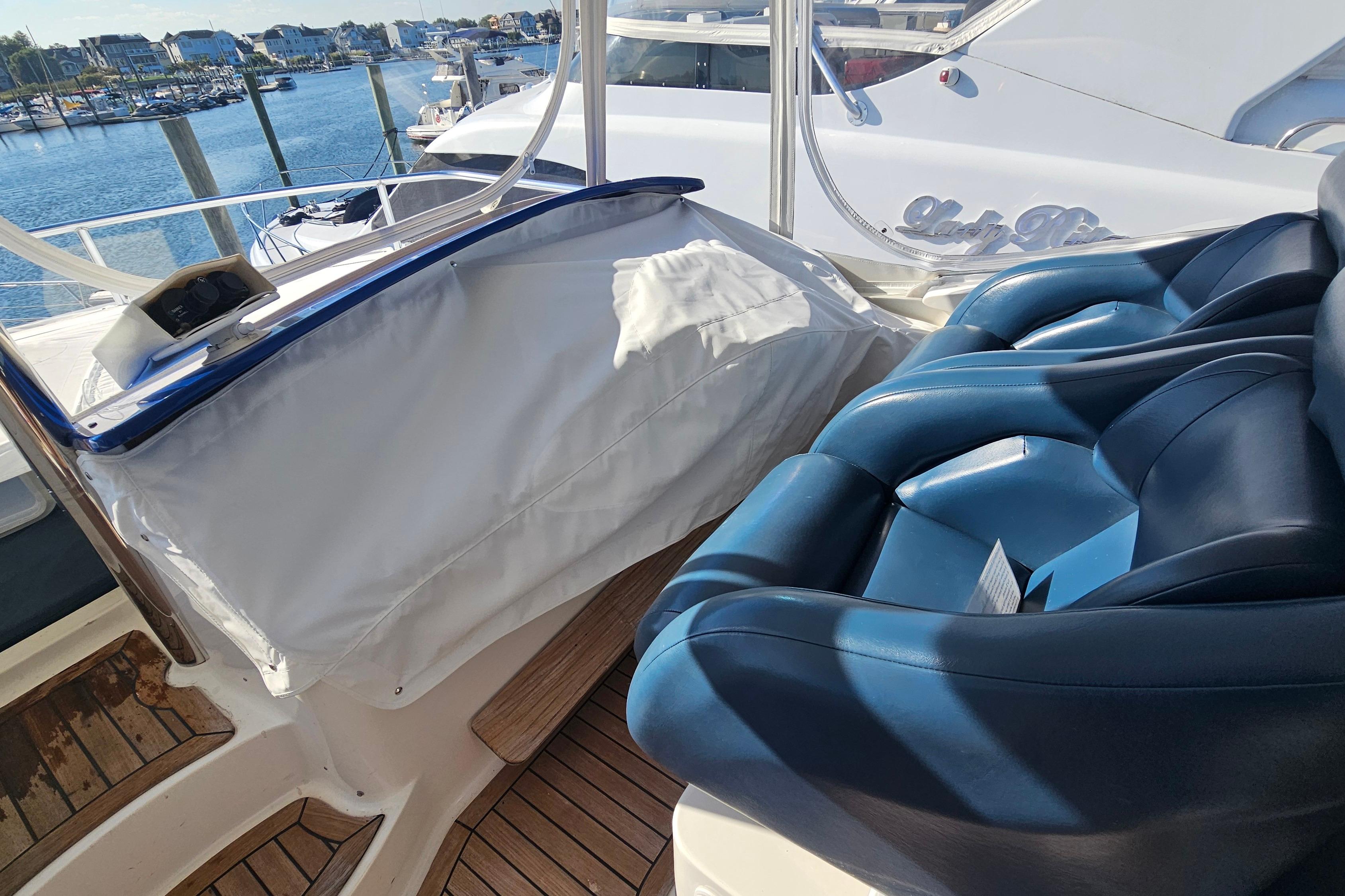 2005 Neptunus 56 Flybridge yacht interior with blue leather seating and marina view.