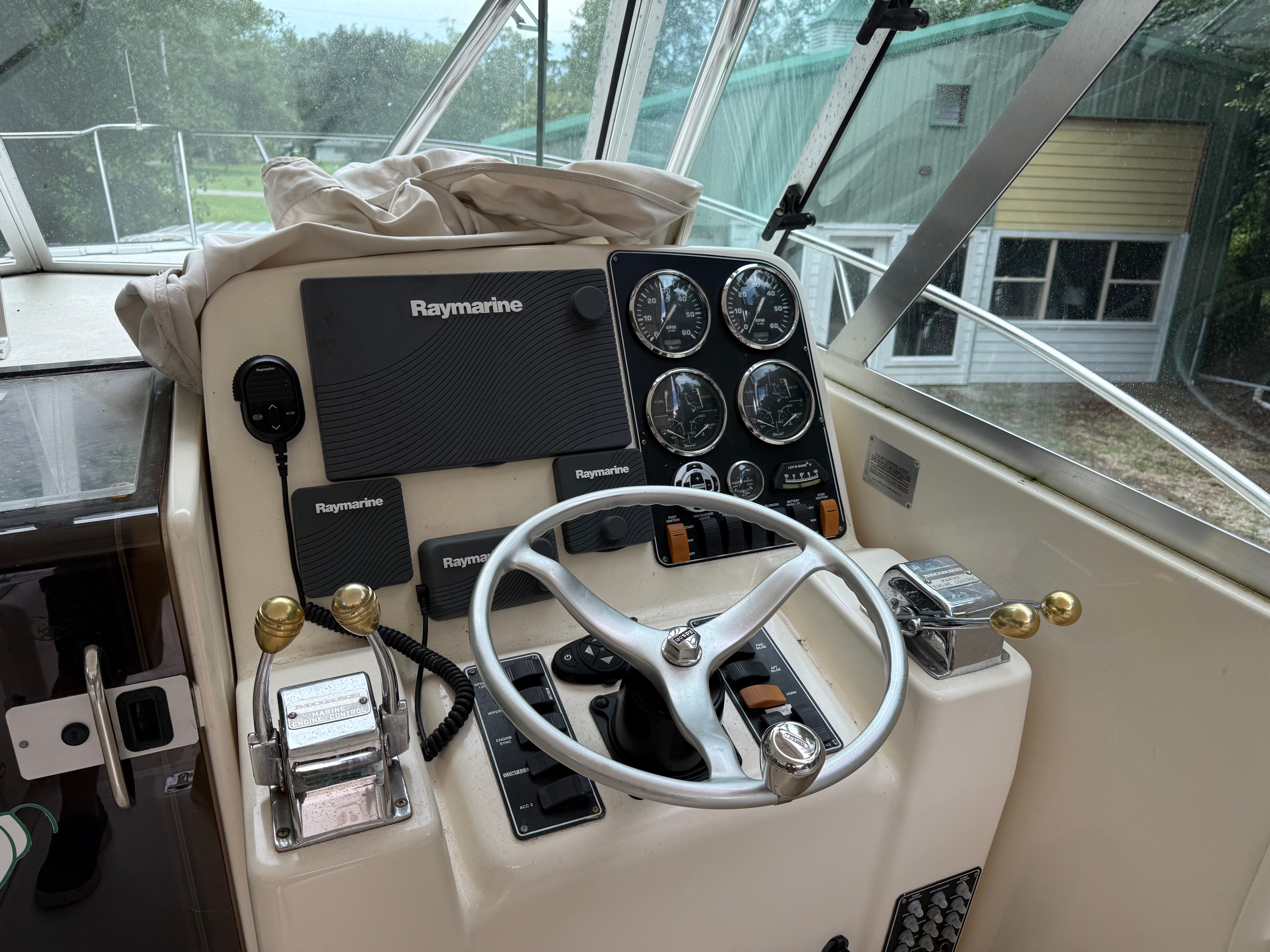 The image shows the helm of a 2002 Pursuit 3000 Express with Raymarine instruments.
