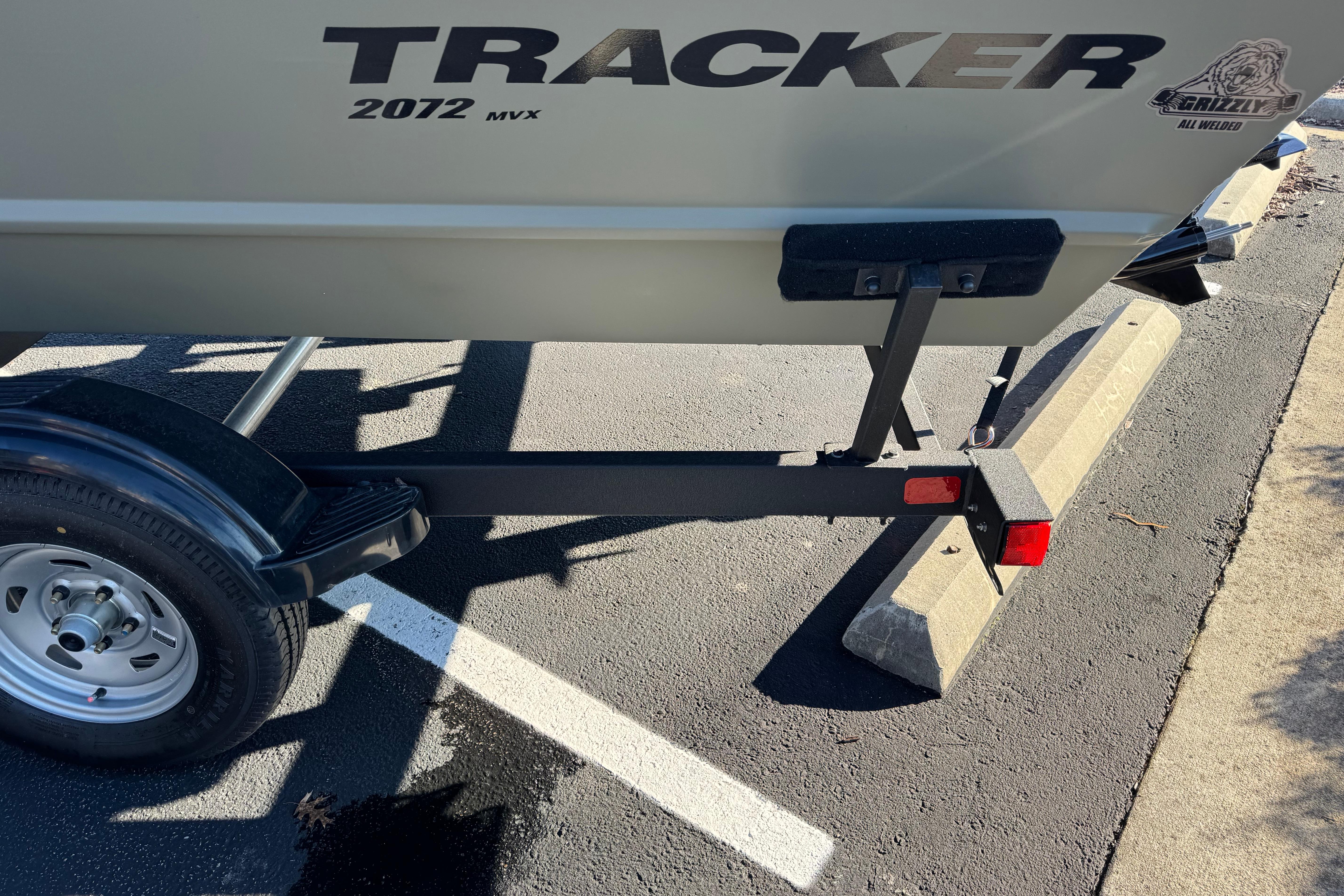2026 Tracker Grizzly 2072 Utility boat on trailer in parking lot.