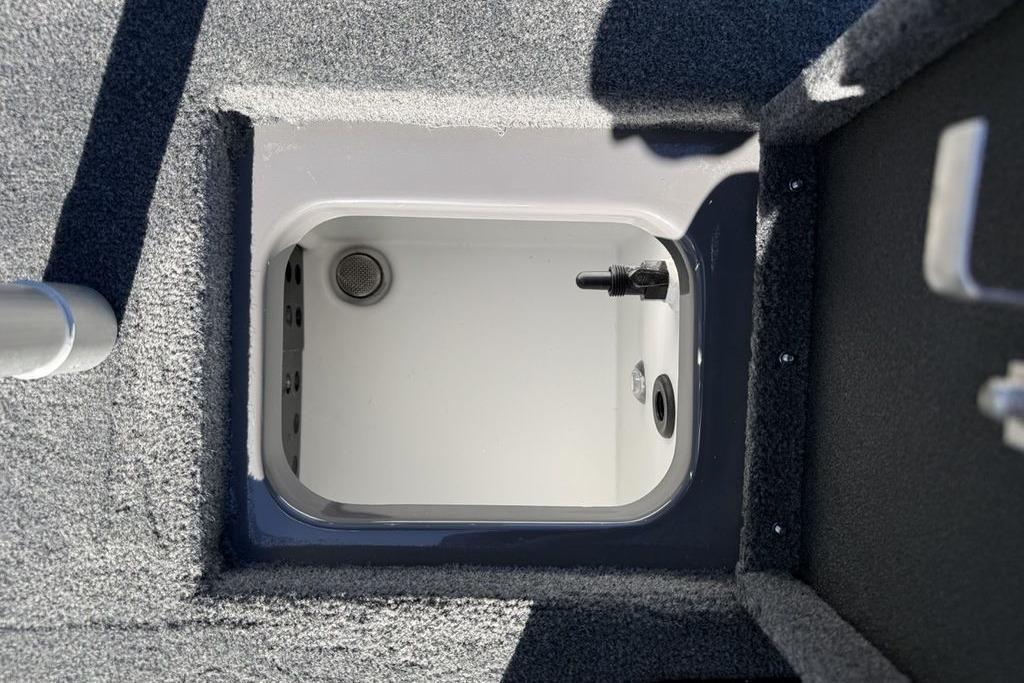 Open storage compartment in 2026 Skeeter ZX150 boat, featuring carpeted interior.