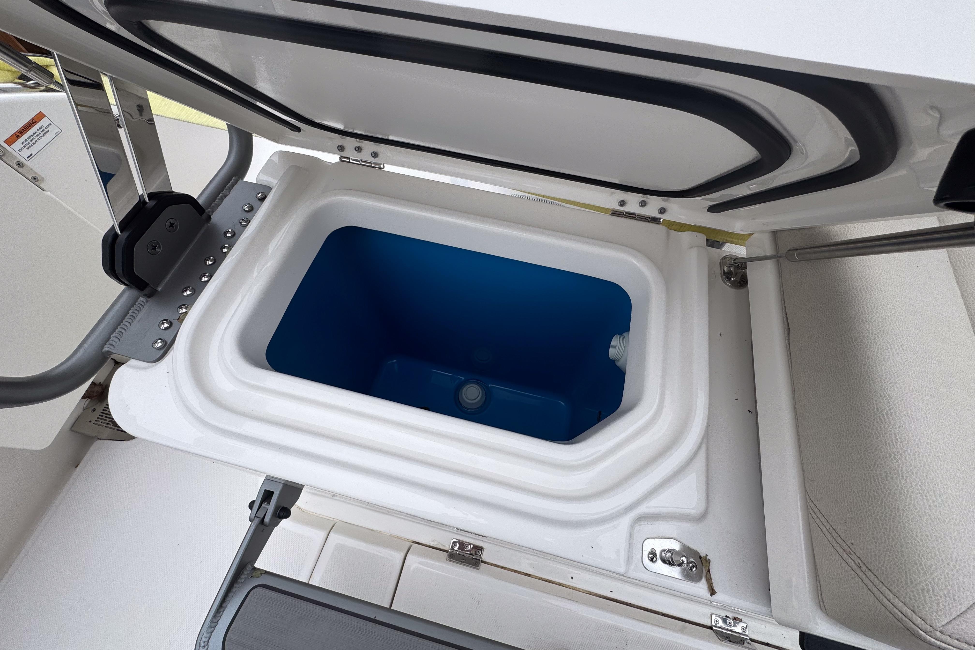 Open storage compartment on 2025 Solace 30 HCS boat, featuring a blue interior.
