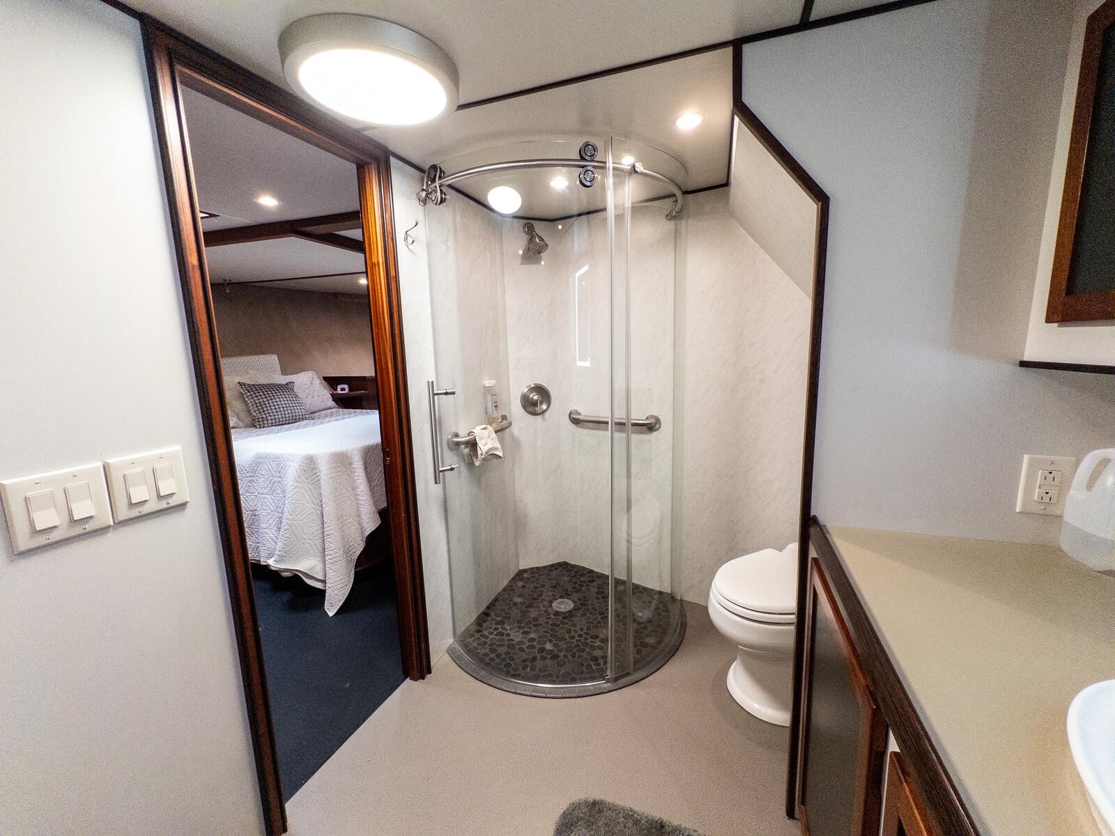 Luxurious bathroom in 1986 Custom Expedition Vessel 58 with modern shower and adjacent bedroom.