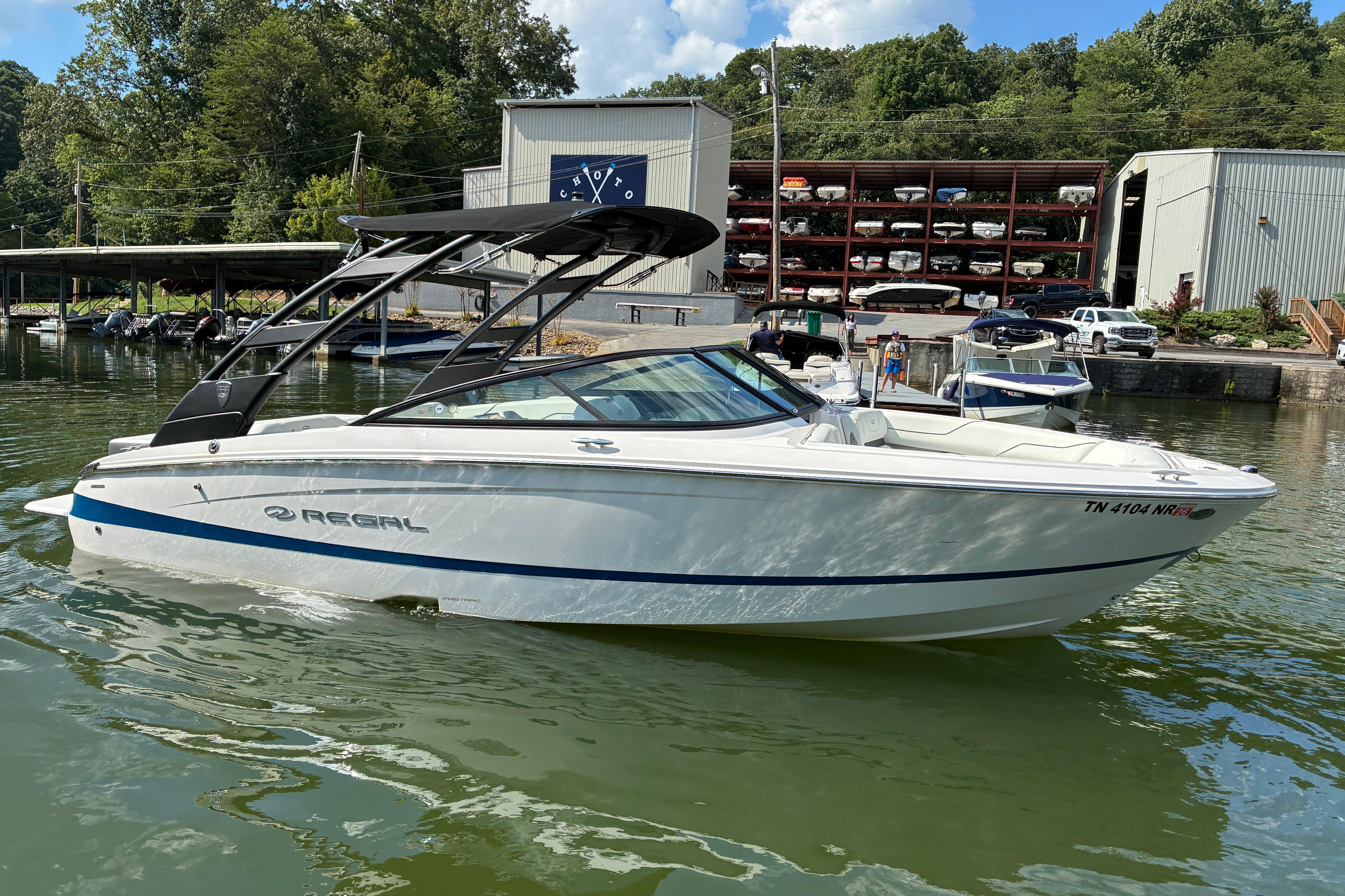 2025 Regal LS2 boat docked on a calm lake with marina background.