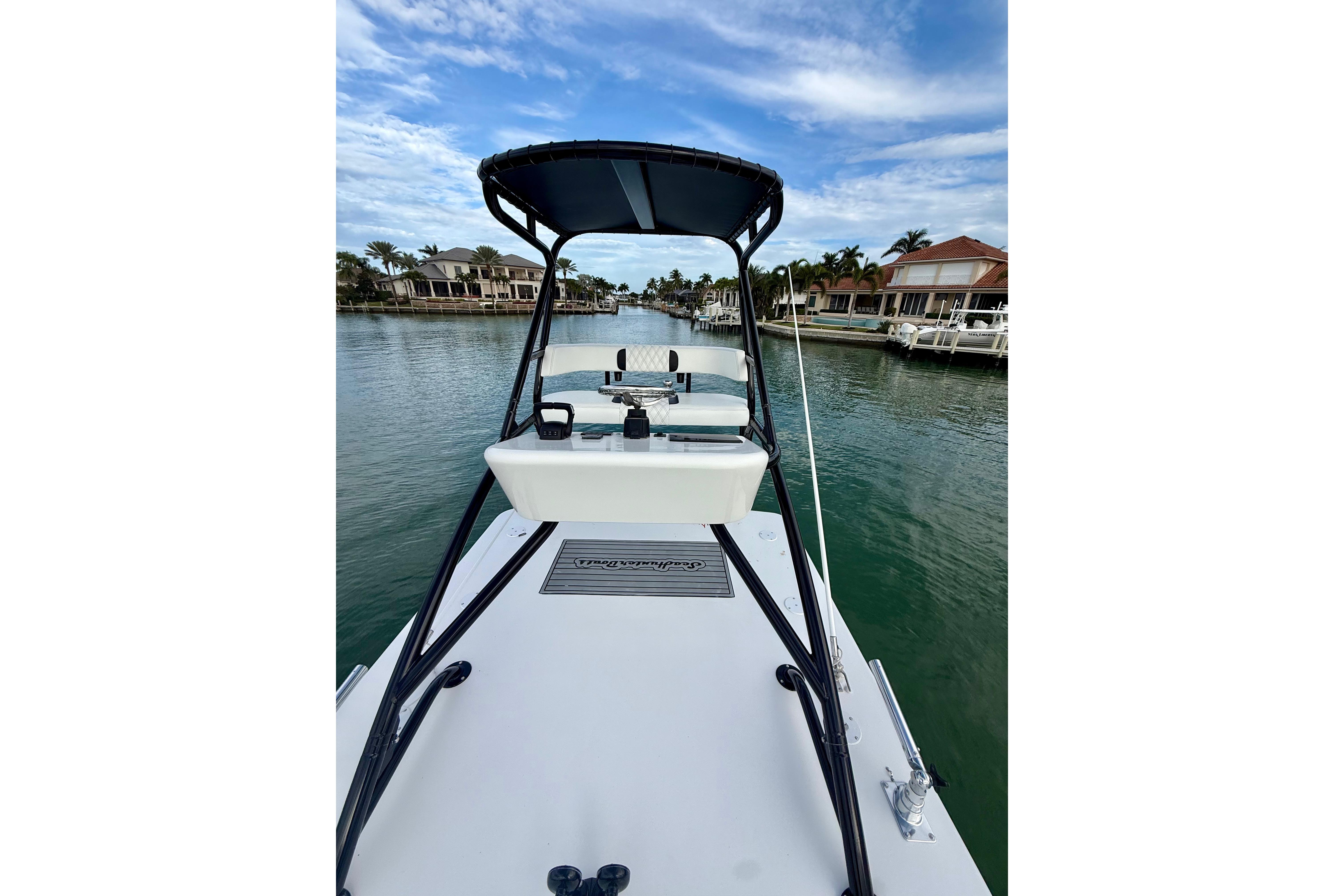 2020 SeaHunter 41 CTS boat on a calm waterway, surrounded by waterfront homes.