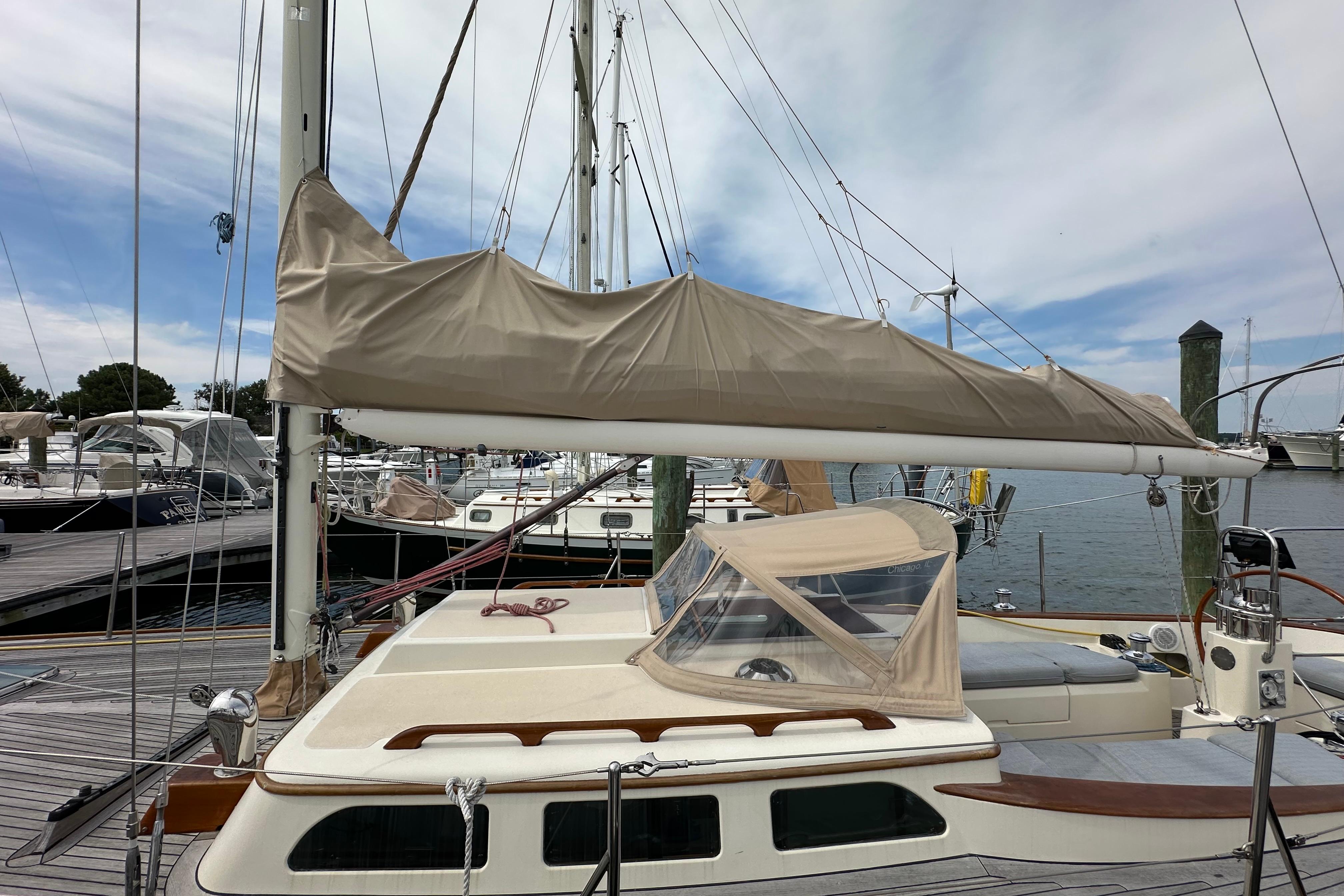 Sailboat docked at marina, Morris M36, 2006 model, with covered sail and clear sky.