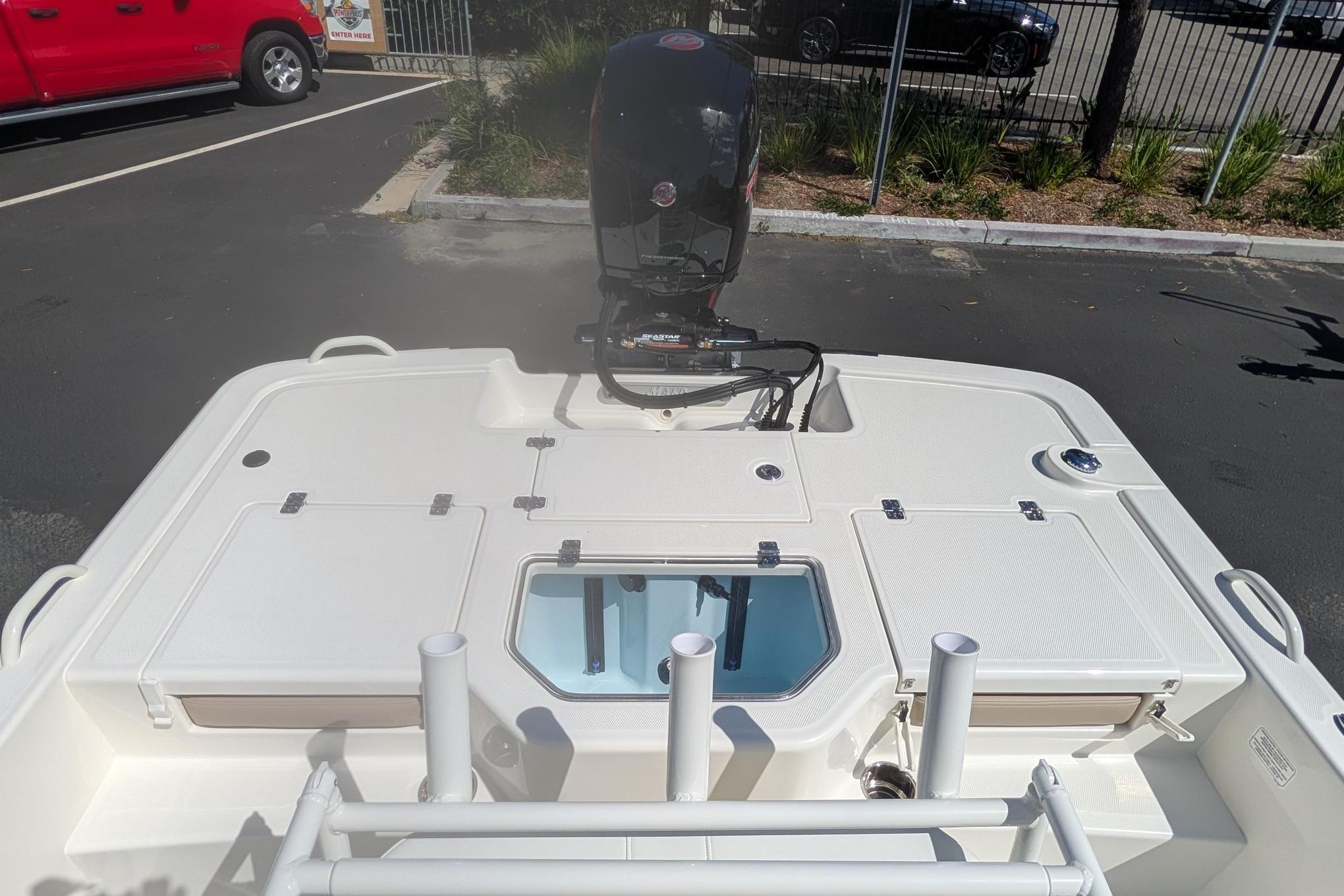 2026 Mako Pro Skiff 19 CC boat with outboard motor in parking lot.
