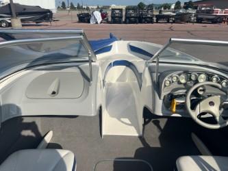 2005 Bayliner 205 Bowrider interior with steering wheel and dashboard, parked outdoors.