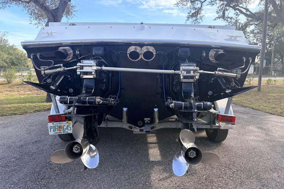 Rear view of a 1983 Cigarette 24' Classic boat on a trailer, showcasing dual propellers.