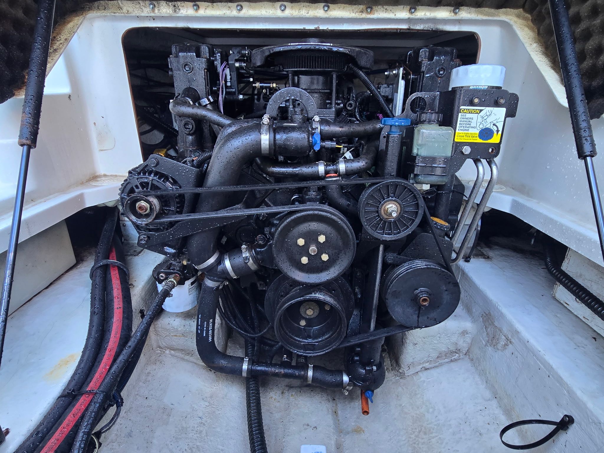 Engine compartment of a 2005 Crownline 240 EX boat with visible engine and components.