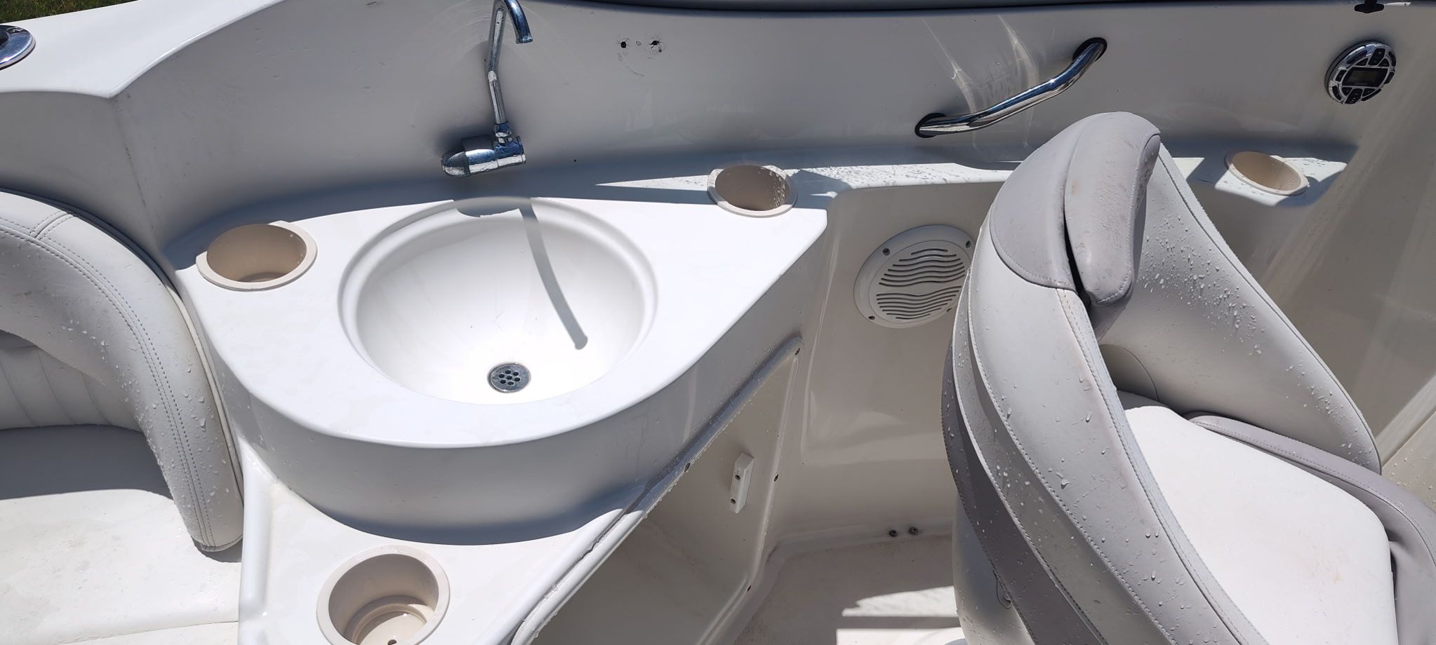 The image shows the cockpit of a 2002 Stingray 240 CR boat with a sink and seating.